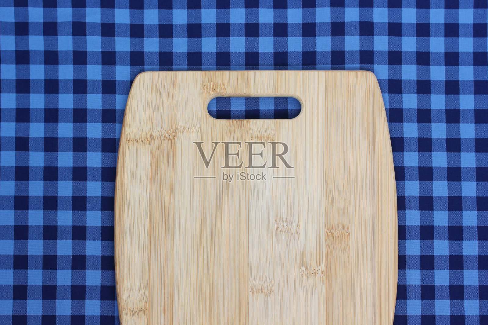 空砧板上的蓝色格子桌布，俯视图。照片摄影图片