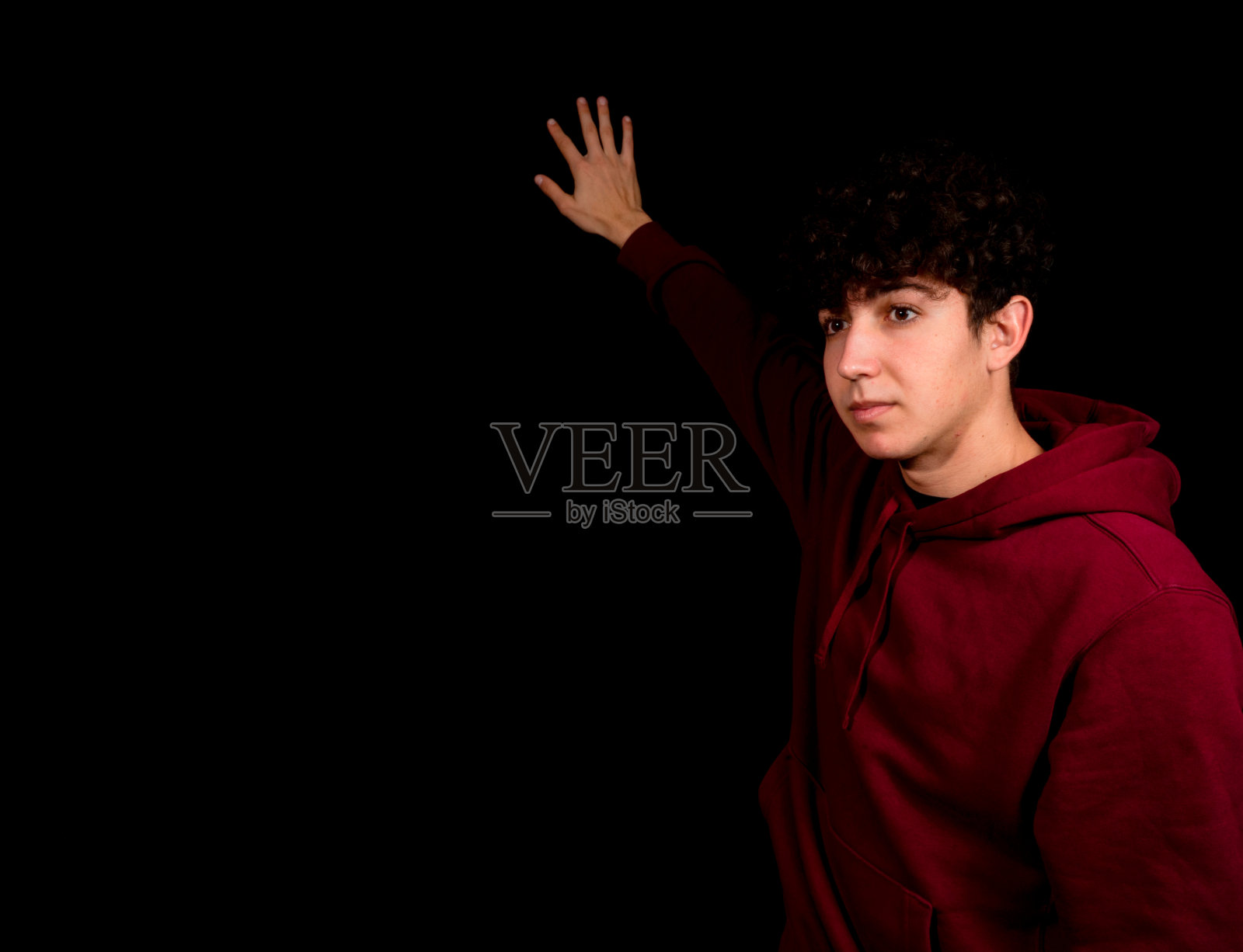 有吸引力的年轻男子与卷发摆姿势的黑色背景照片摄影图片