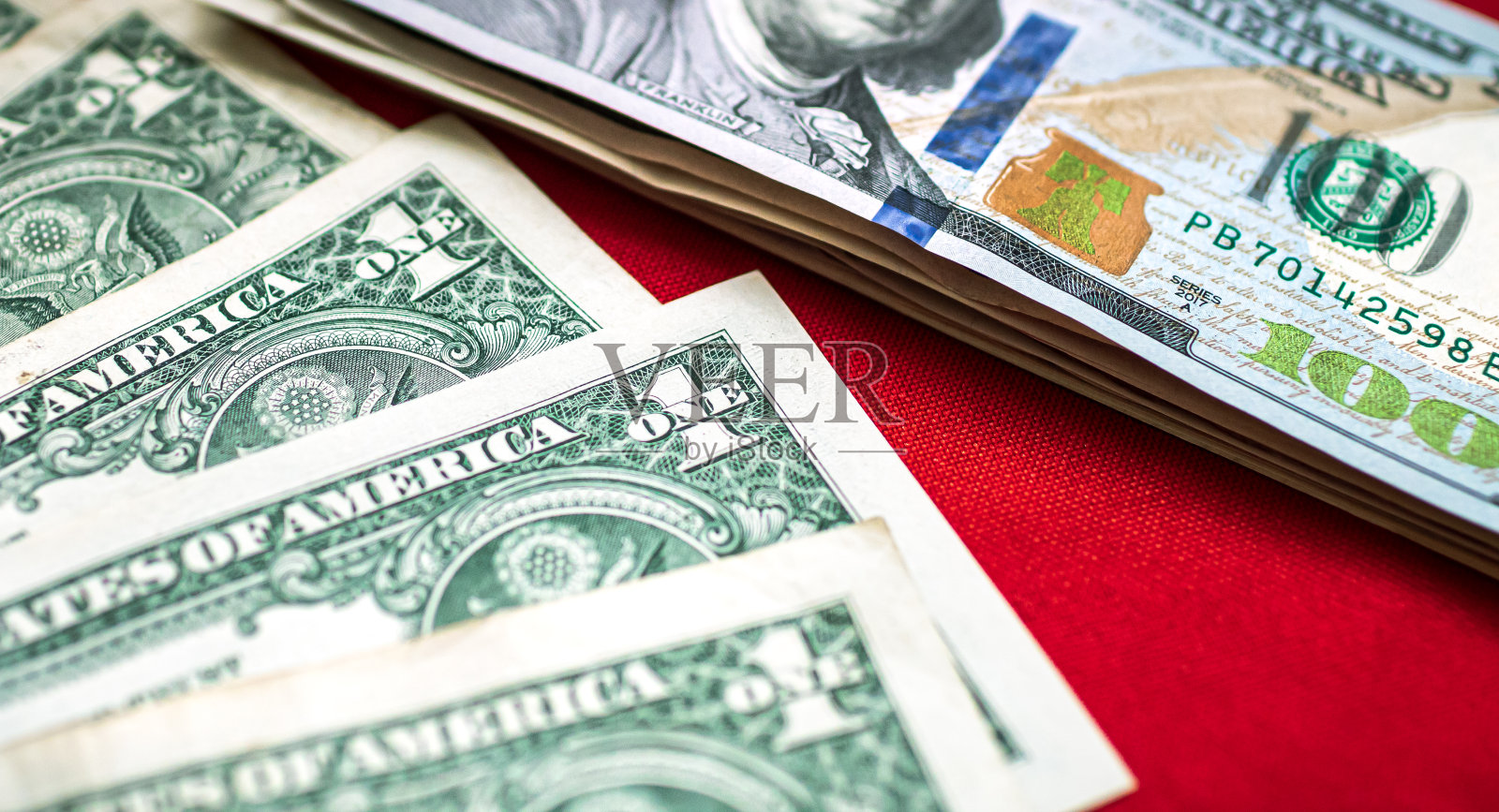 货币，美元纸币背景。钞票放在铺着红布的桌子上。金融和经济概念摄影。照片摄影图片