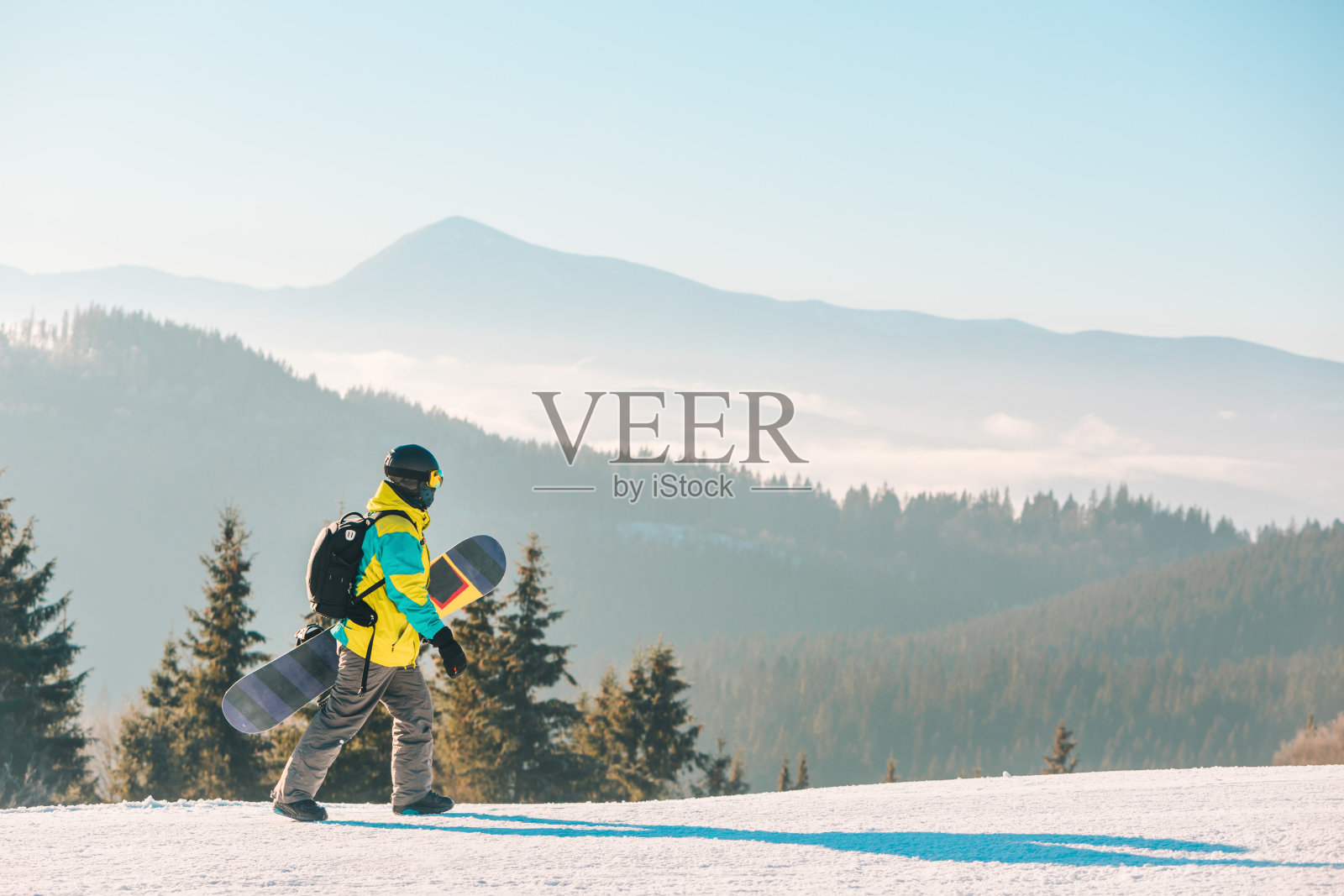带着滑雪板在山上行走的人照片摄影图片