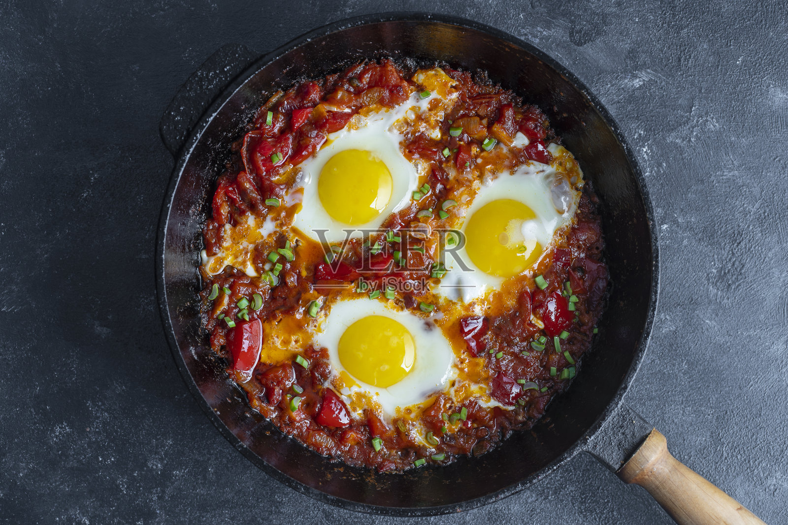 Shakshuka，用番茄、洋葱、红辣椒和香料在铸铁锅里煎蛋照片摄影图片