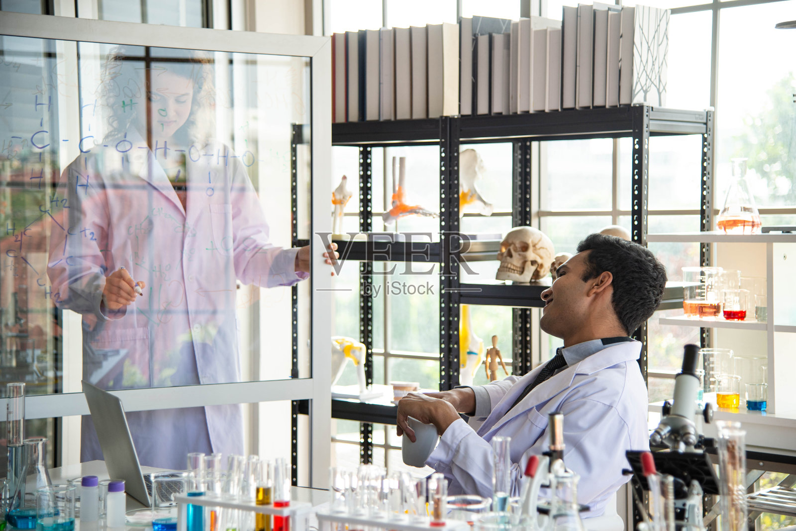 在实验室做化学研究的年轻科学家或研究人员。研究计算机和实验室设备的科学家。照片摄影图片