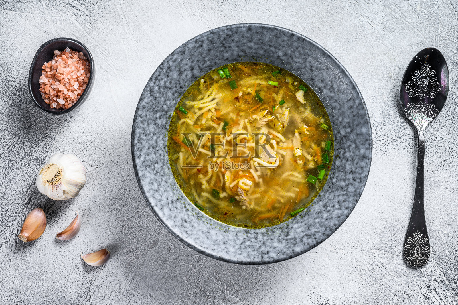 鸡肉清汤，配韭菜，胡萝卜，面条，葱和欧芹。白色背景。俯视图照片摄影图片