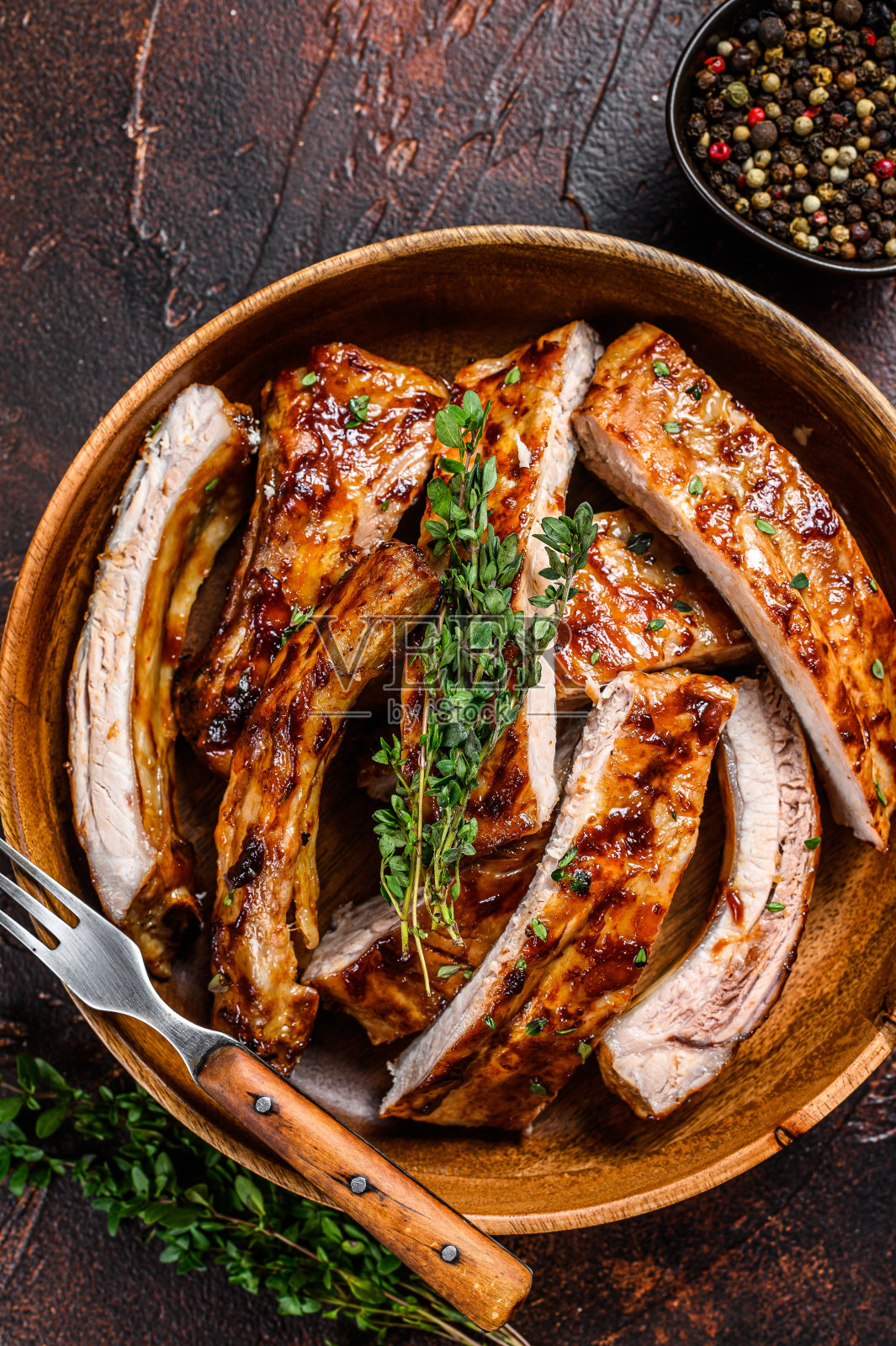 切烧烤叉烧排骨在木盘。黑暗的背景。俯视图照片摄影图片