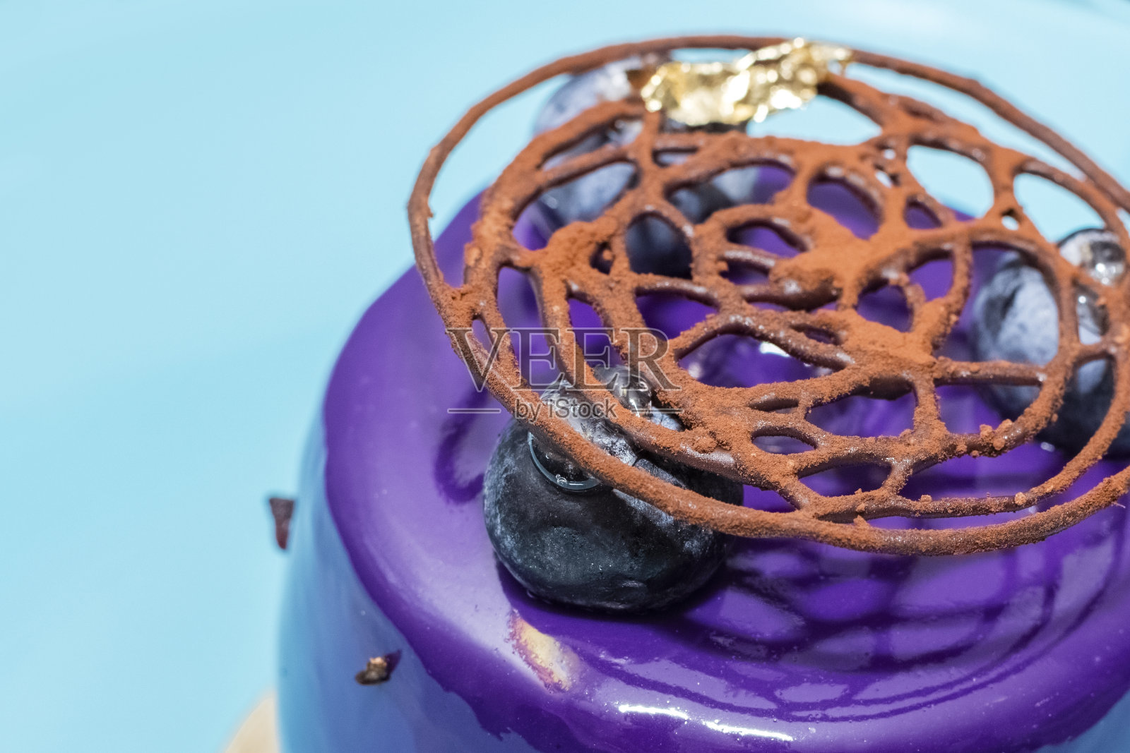 装饰漂亮的巧克力和可可蓝莓蛋糕。蓝色背景照片摄影图片