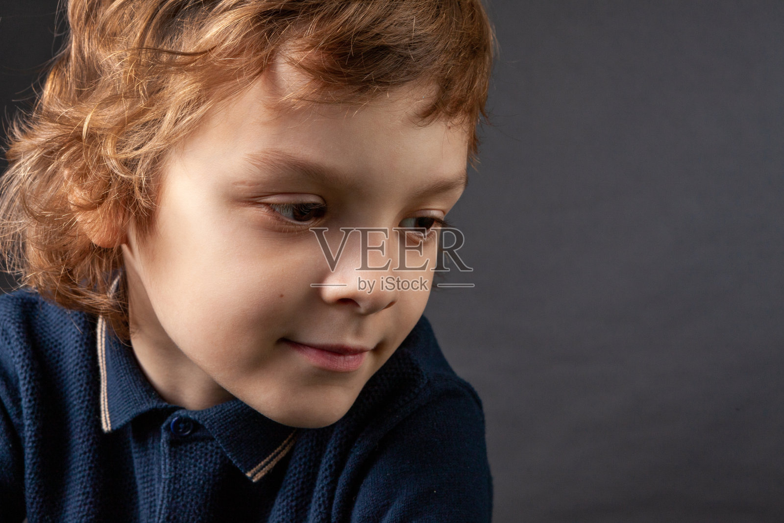 7岁男孩的工作室肖像与棕色长发照片摄影图片