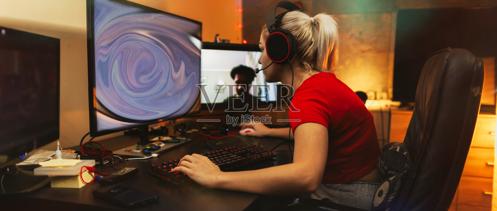 十几岁的女孩在他的暗室里用桌面电脑玩多人游戏照片摄影图片