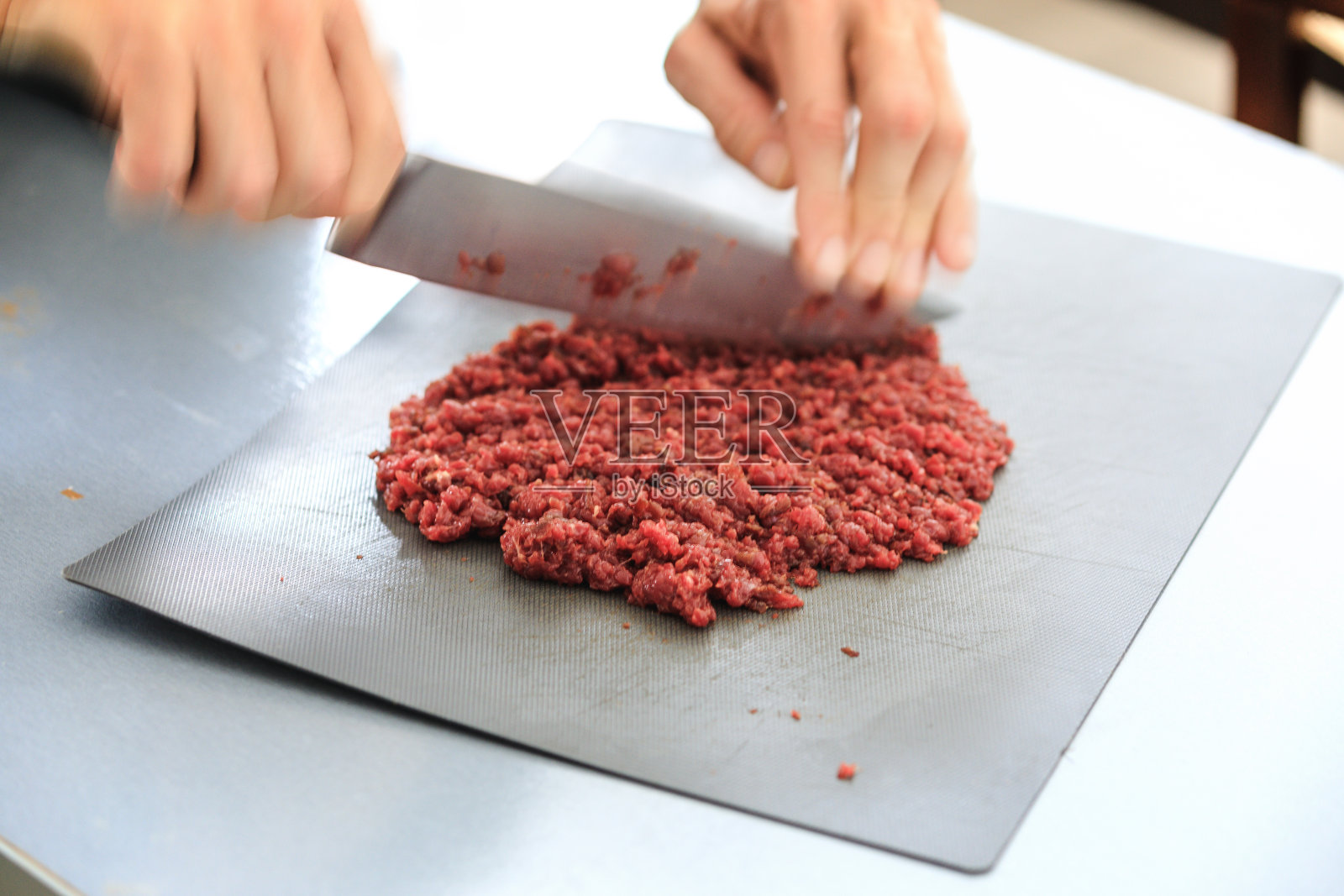 鞑靼牛排准备，马肉用锋利的刀切碎照片摄影图片