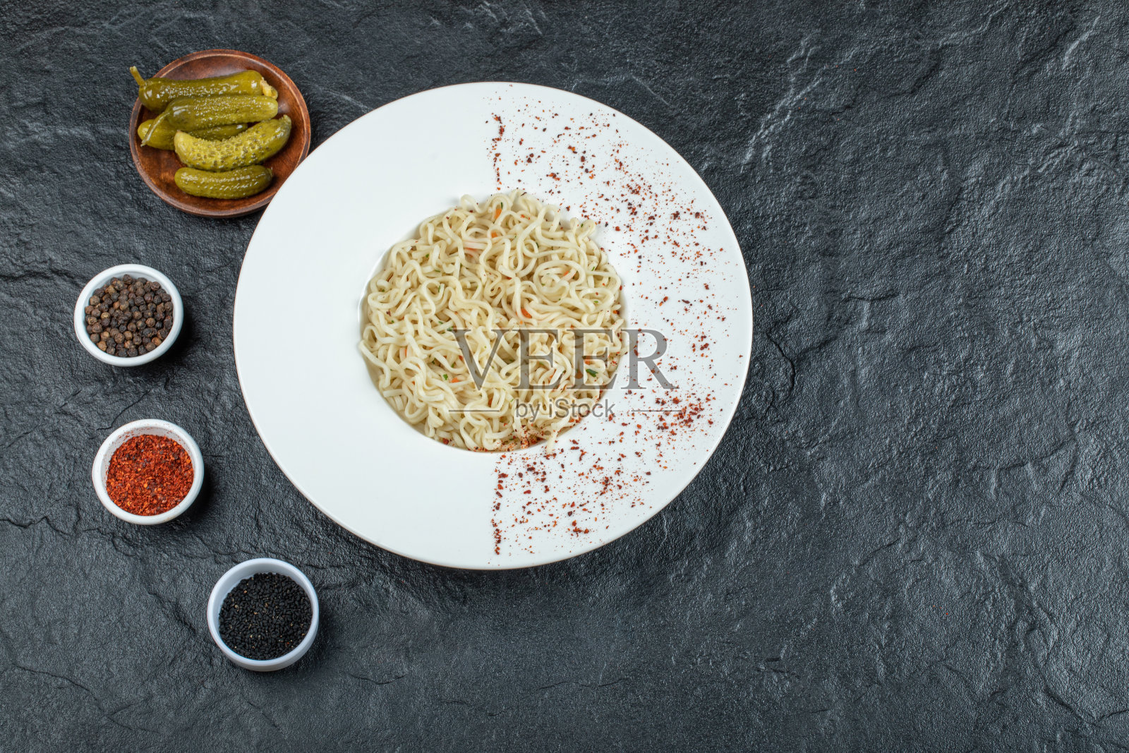 一个白色的盘子，上面有美味的面条和腌黄瓜照片摄影图片