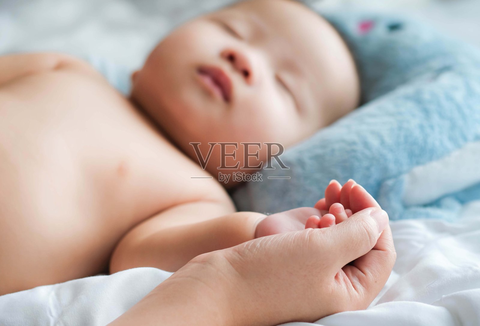 选择性的将熟睡的宝宝的手放在妈妈的手上贴近床上，新的家庭和宝宝从妈妈保护的概念照片摄影图片