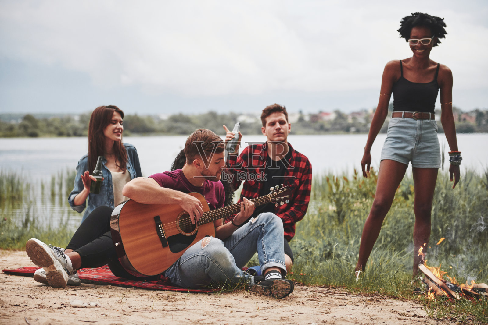 感觉的音乐。一群人在海滩上野餐。朋友们在周末玩得很开心照片摄影图片