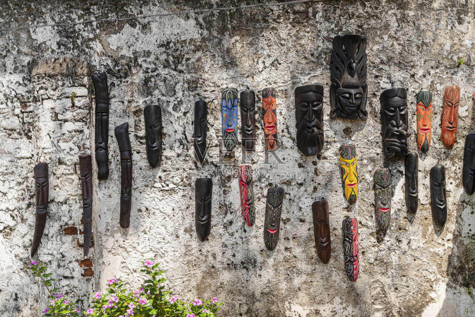 挂在墙上的面具。自然背景-斯里兰卡加勒古城墙的纹理。照片摄影图片