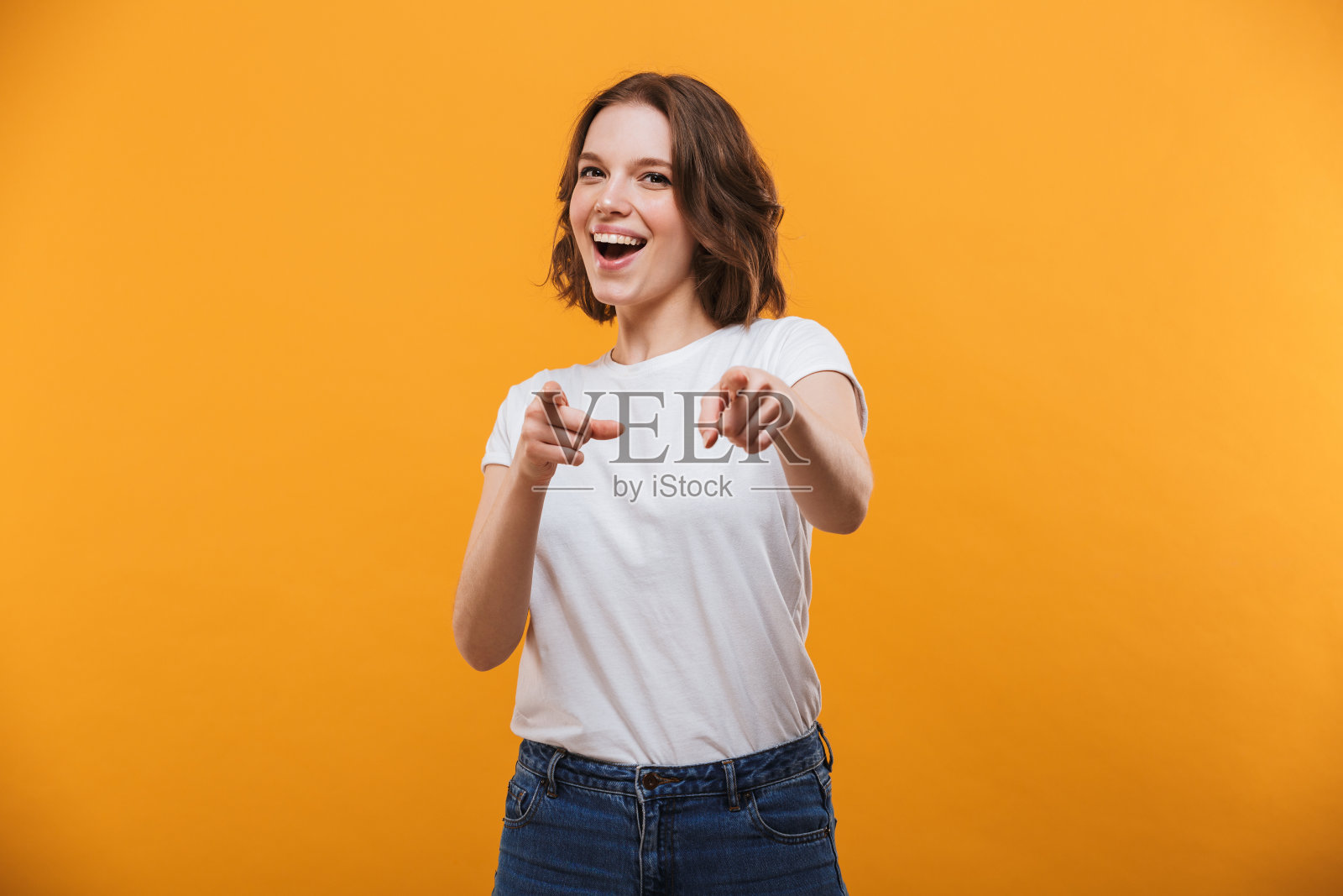 快乐的年轻女人指着你。照片摄影图片