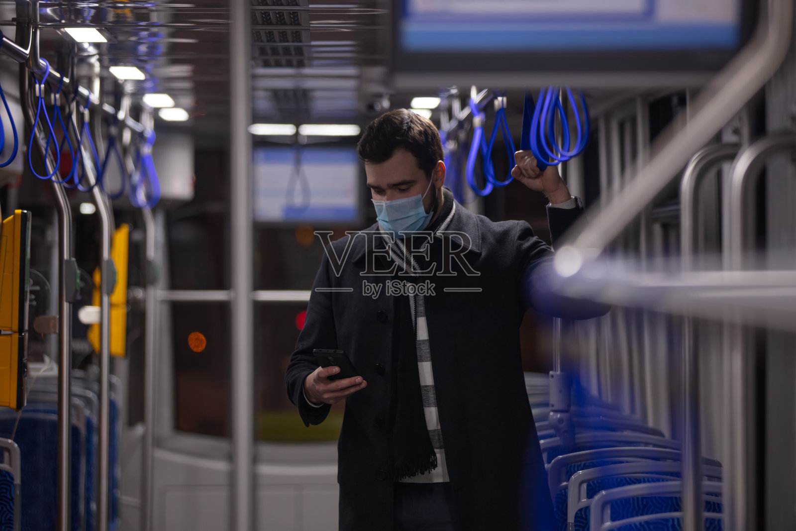 波兰大流行期间，一个戴着面具的孤独男子在夜间乘坐电车照片摄影图片