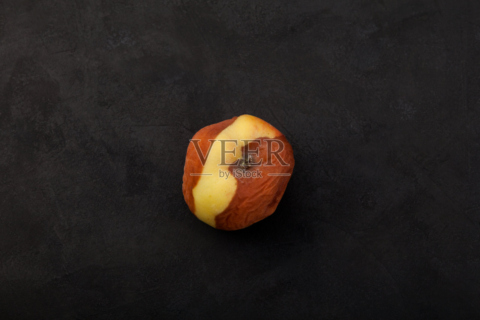 腐烂腐烂的苹果在深色纹理背景与文字空间。不适当的储存食物。概念-减少有机废物照片摄影图片