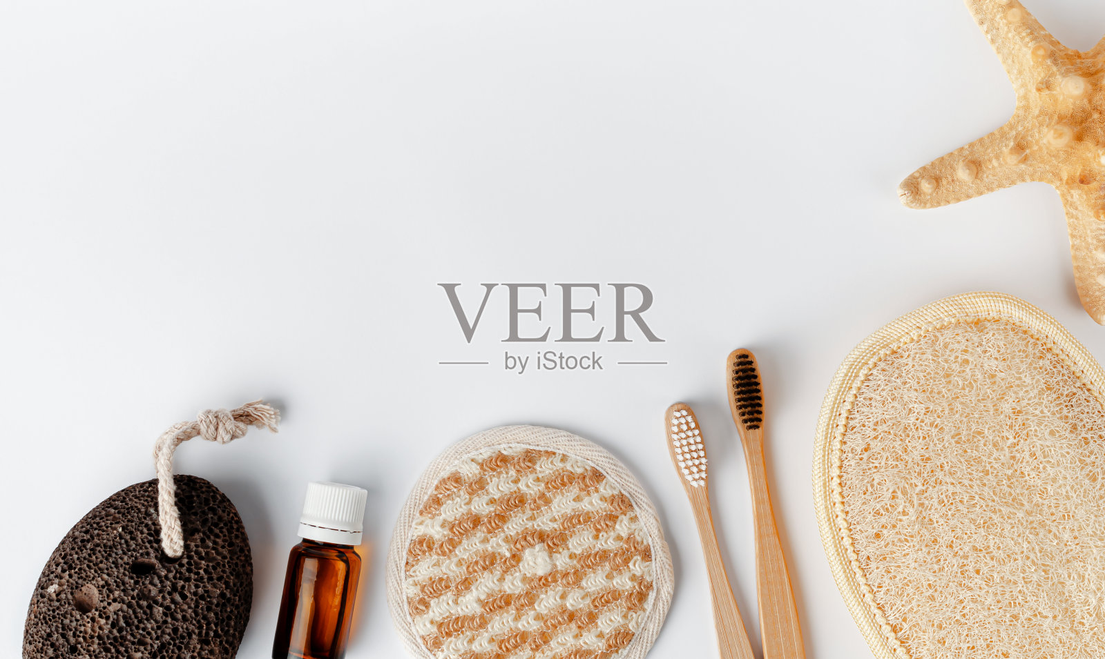 竹牙刷，脸部和身体海绵，精油和浮石在白色的背景。副本的空间。生态浴室配件照片摄影图片