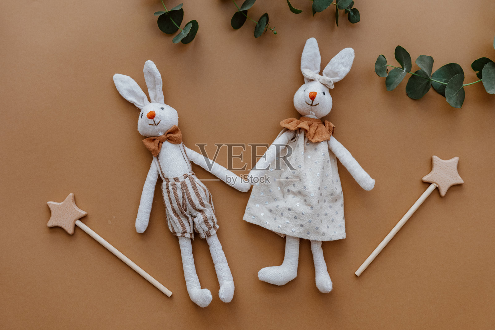 棕色背景上的两个兔子玩具。俯视图，平放照片摄影图片