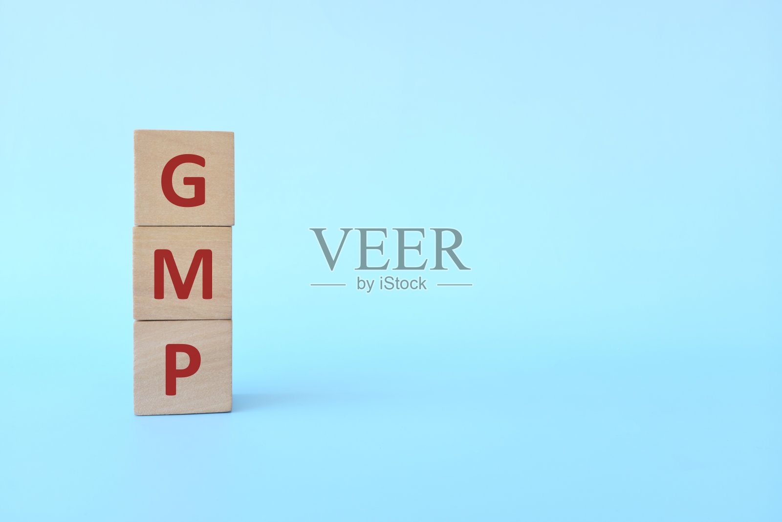 GMP字文本在蓝色背景的木块上复制空间。食品工业良好生产规范。照片摄影图片