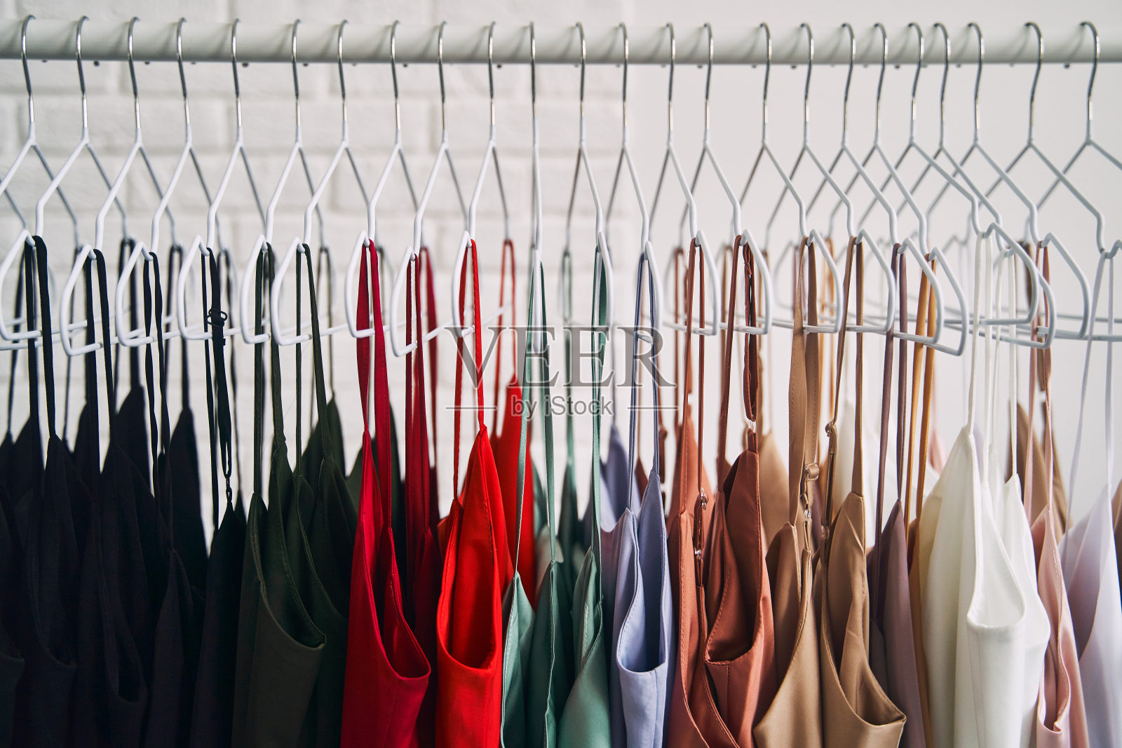 商店里五颜六色的衣服挂在衣架上。销售女装照片摄影图片