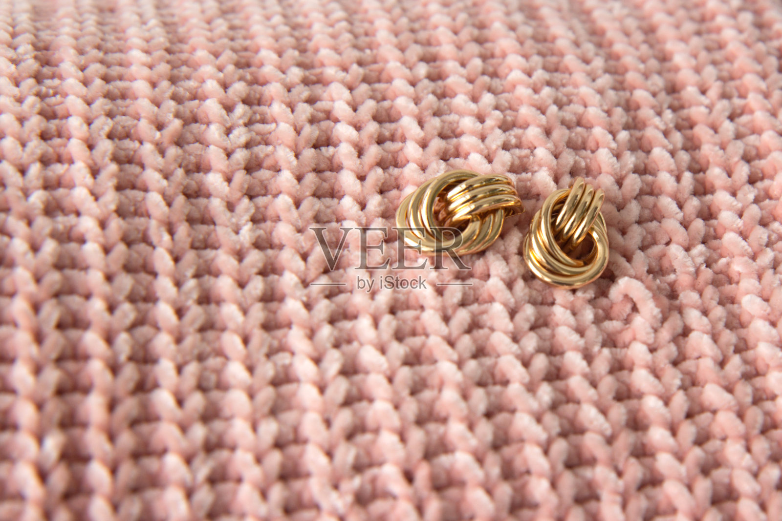 两对漂亮的金耳环，针织面料的纹理照片摄影图片
