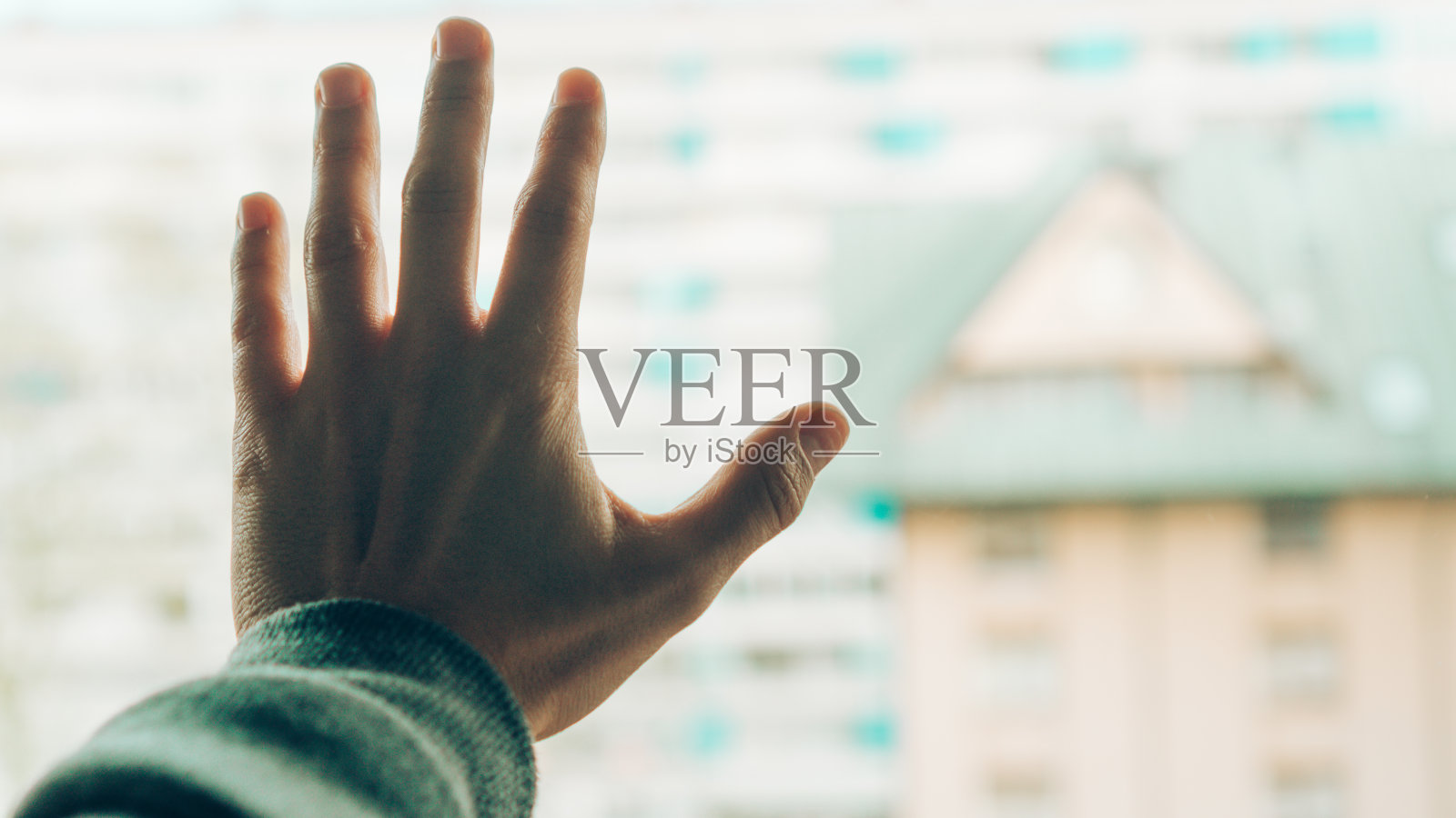 在家监禁时把手靠在窗户上的人照片摄影图片