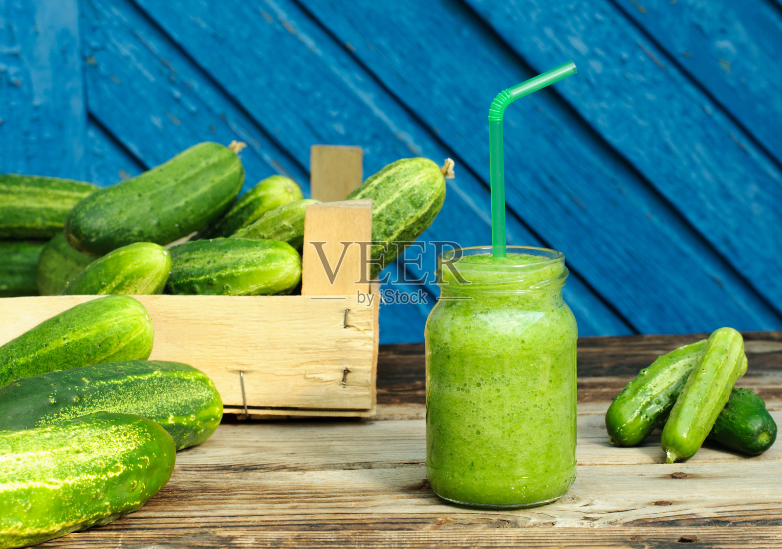 瓶子里的黄瓜冰沙和木质背景上的整根黄瓜照片摄影图片