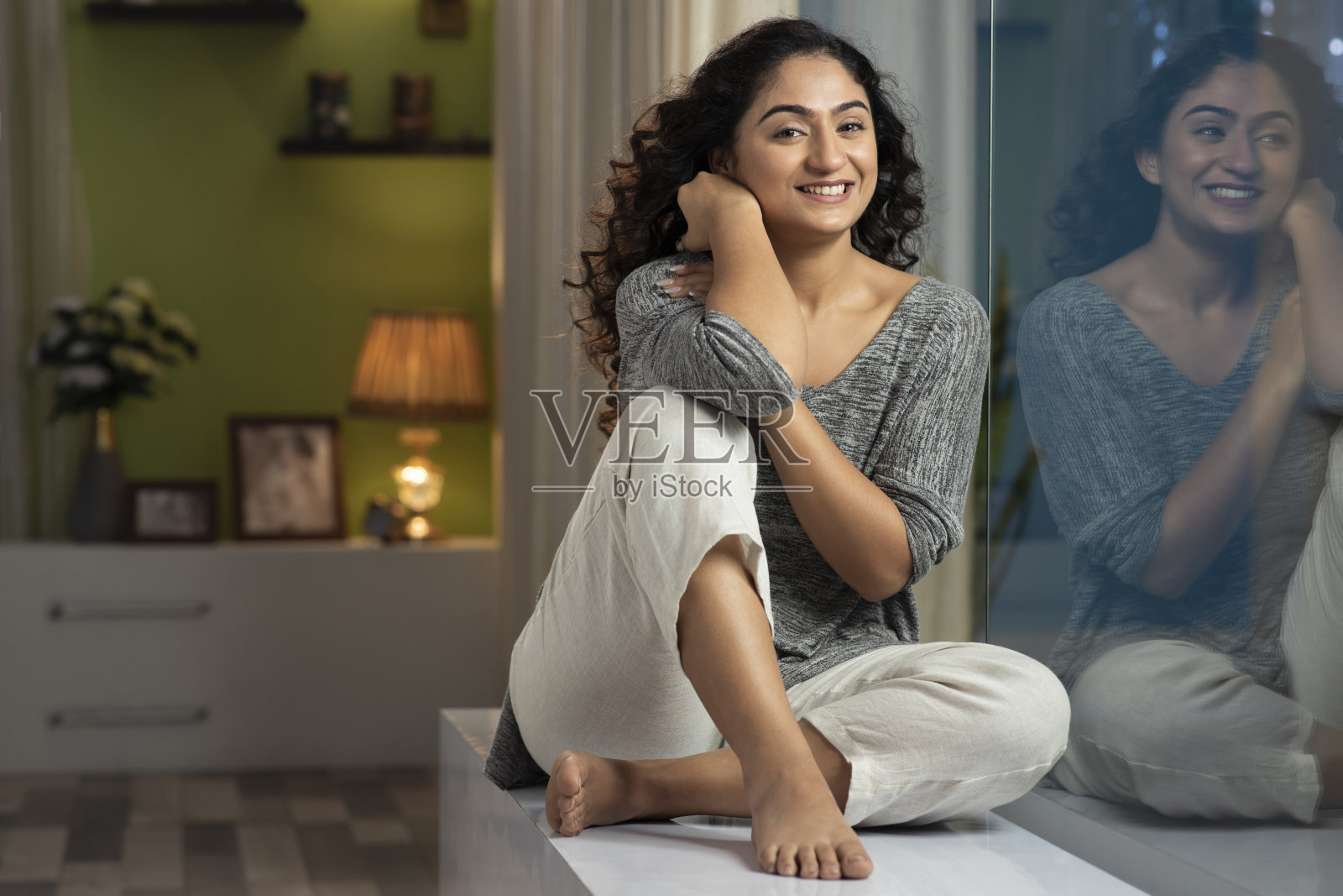 一个年轻女人坐在家里窗台上的照片，库存照片照片摄影图片