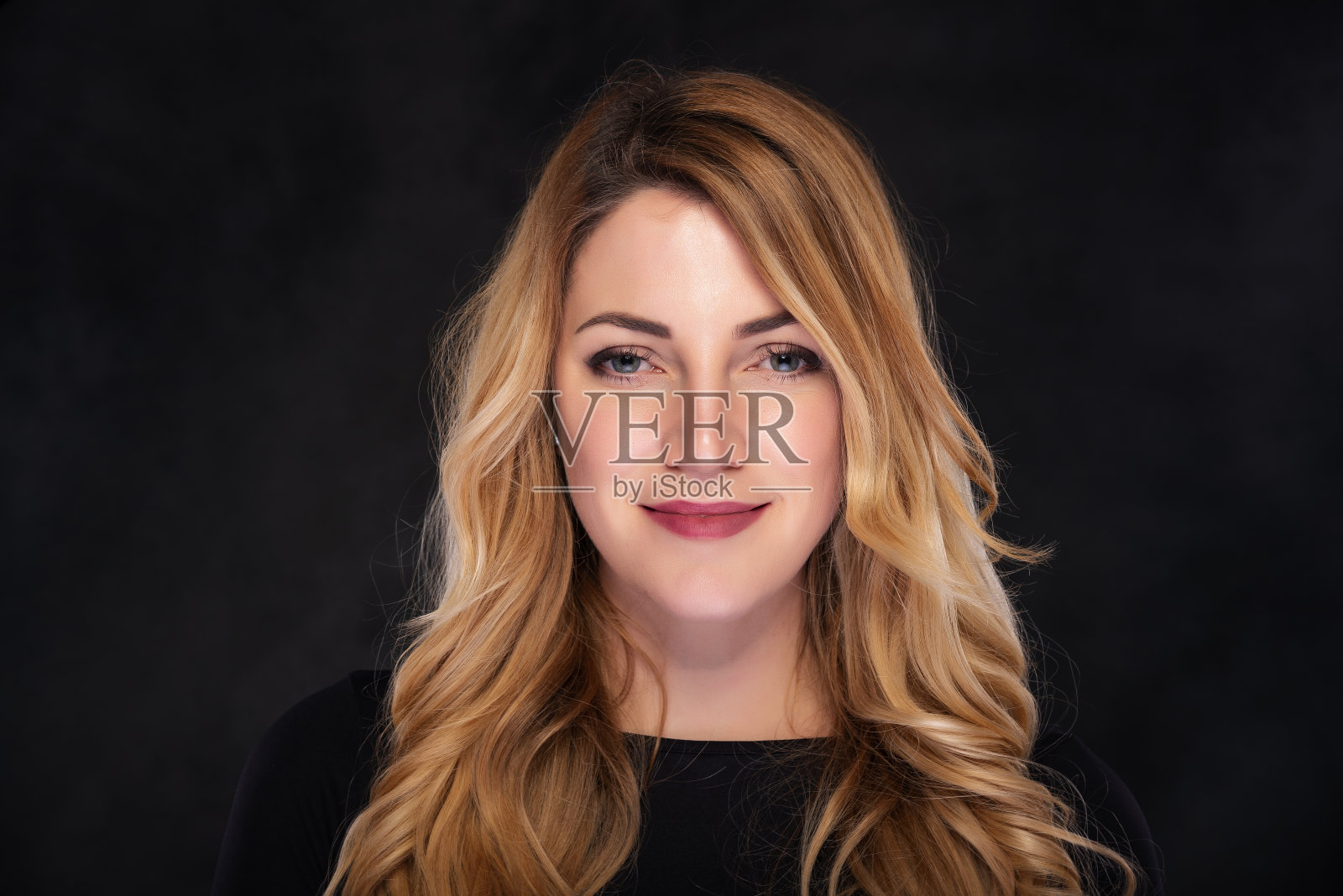 美丽年轻的金发女人在黑暗的背景照片摄影图片