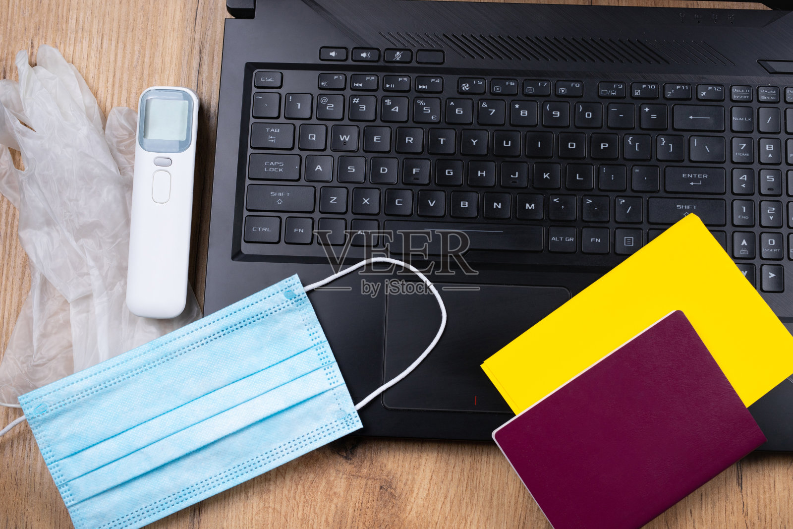 使用笔记本电脑在线订票。所需文件:护照，国际证明疫苗接种，口罩，手套和温度计。在大流行中负责任旅行的概念照片摄影图片