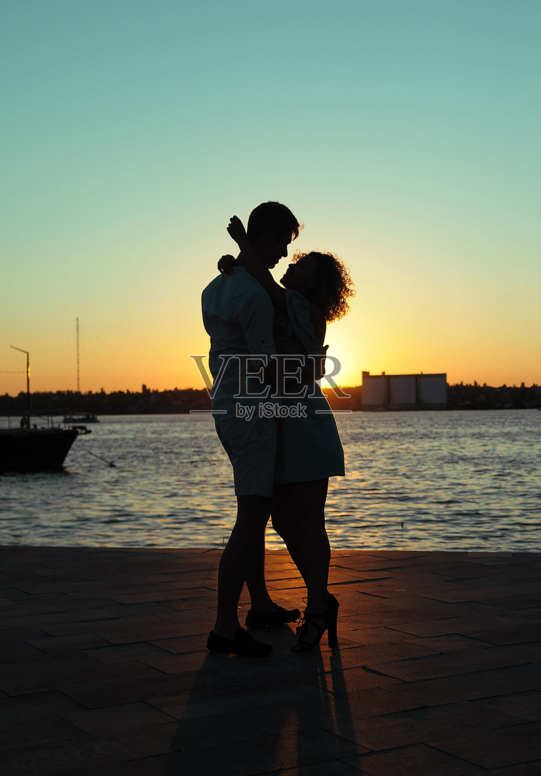 一对幸福的情侣在海滩上夕阳下跳舞照片摄影图片