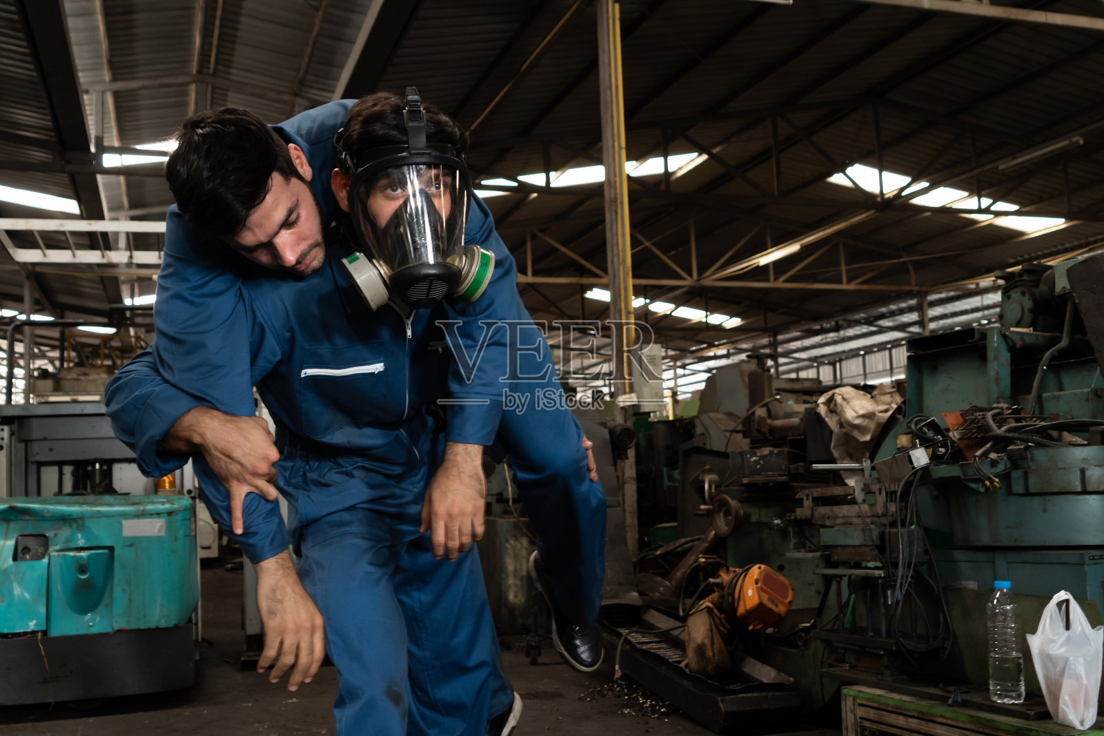 熟练的工厂工人从毒气泄漏中救出他的队友照片摄影图片