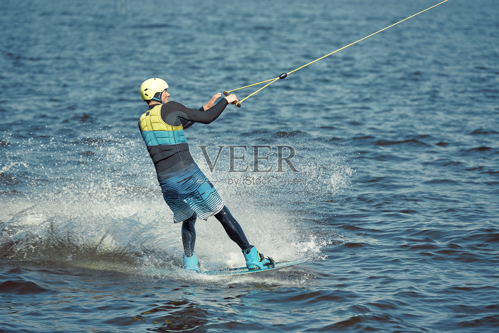 那家伙在河上玩尾流板。积极运动和极限运动照片摄影图片
