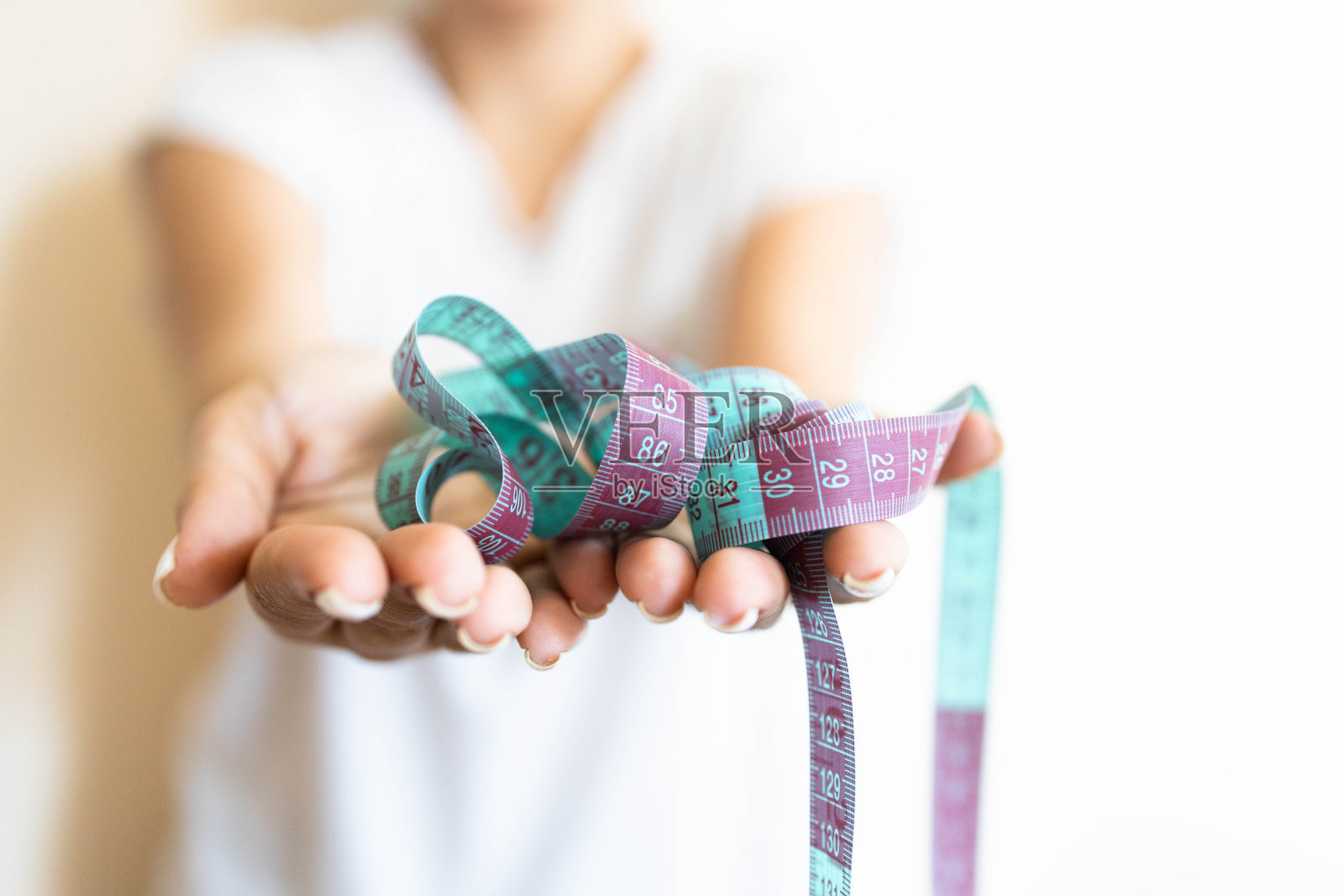 女人的手拿着裁缝卷尺照片摄影图片