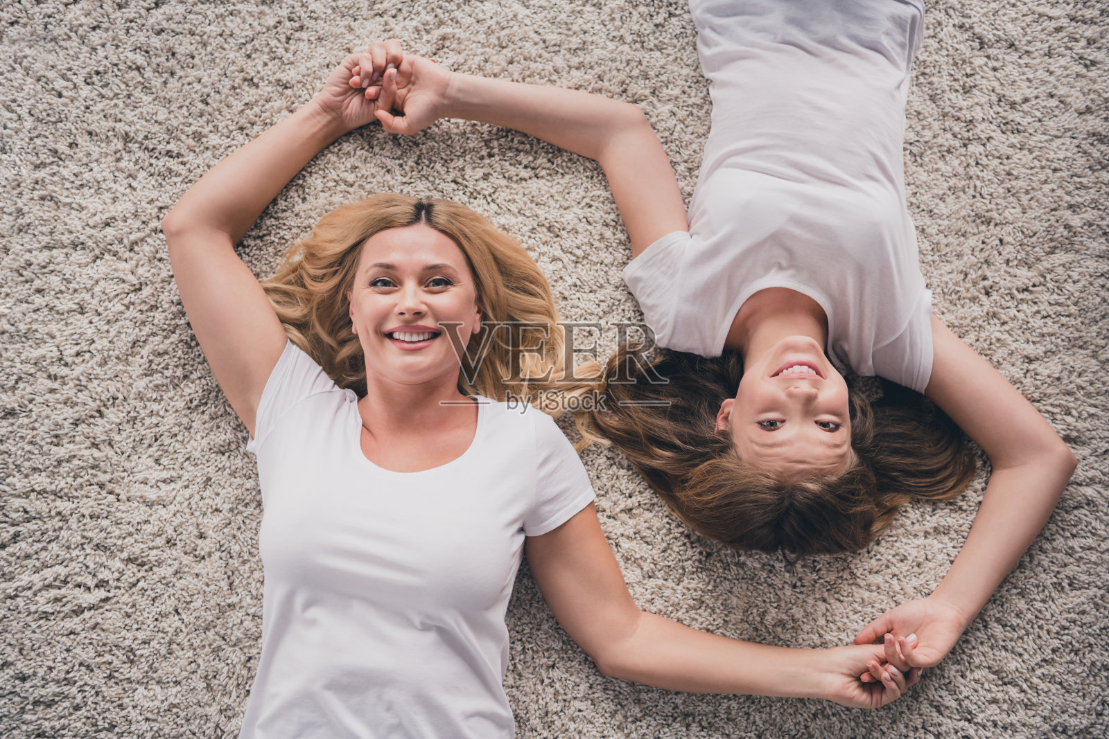 楼上楼上高角度观照片，欢快的母女在屋里牵着手和谐好心情照片摄影图片