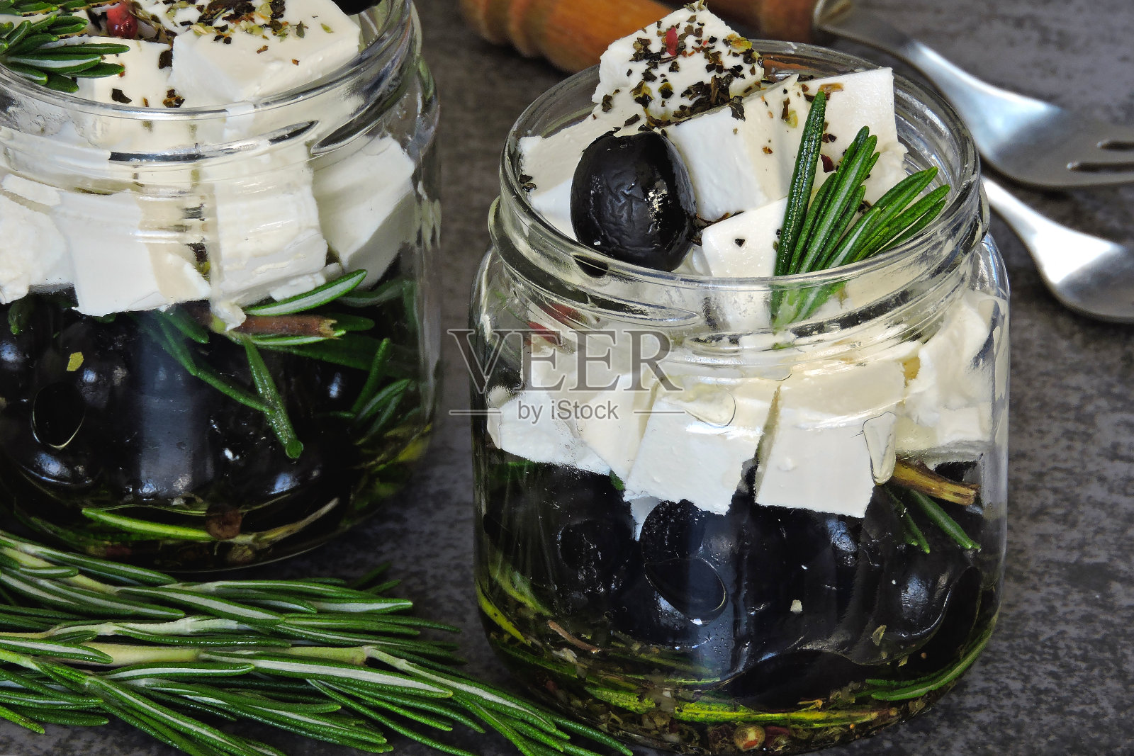 在橄榄油中加入橄榄，羊乳酪和迷迭香。照片摄影图片