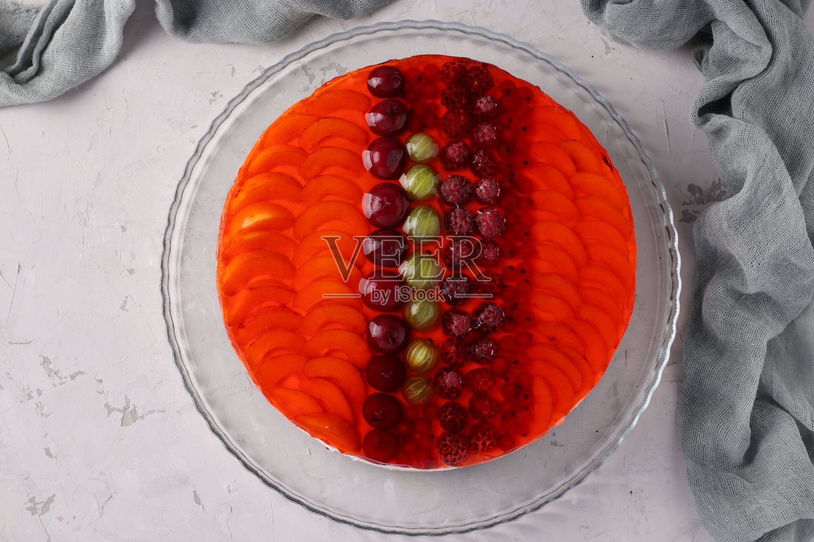 红色果冻蛋糕，水果和酸奶油在灰色的背景。平的。从上面的观点照片摄影图片