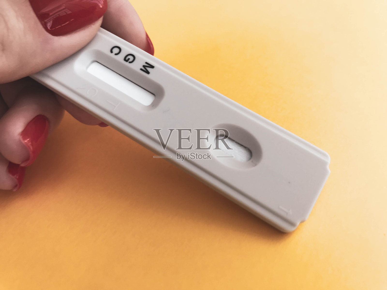 医疗程序。亮黄色背景上的冠状病毒测试。新的家庭自我诊断工具包。修了红色指甲的女孩要去验血照片摄影图片