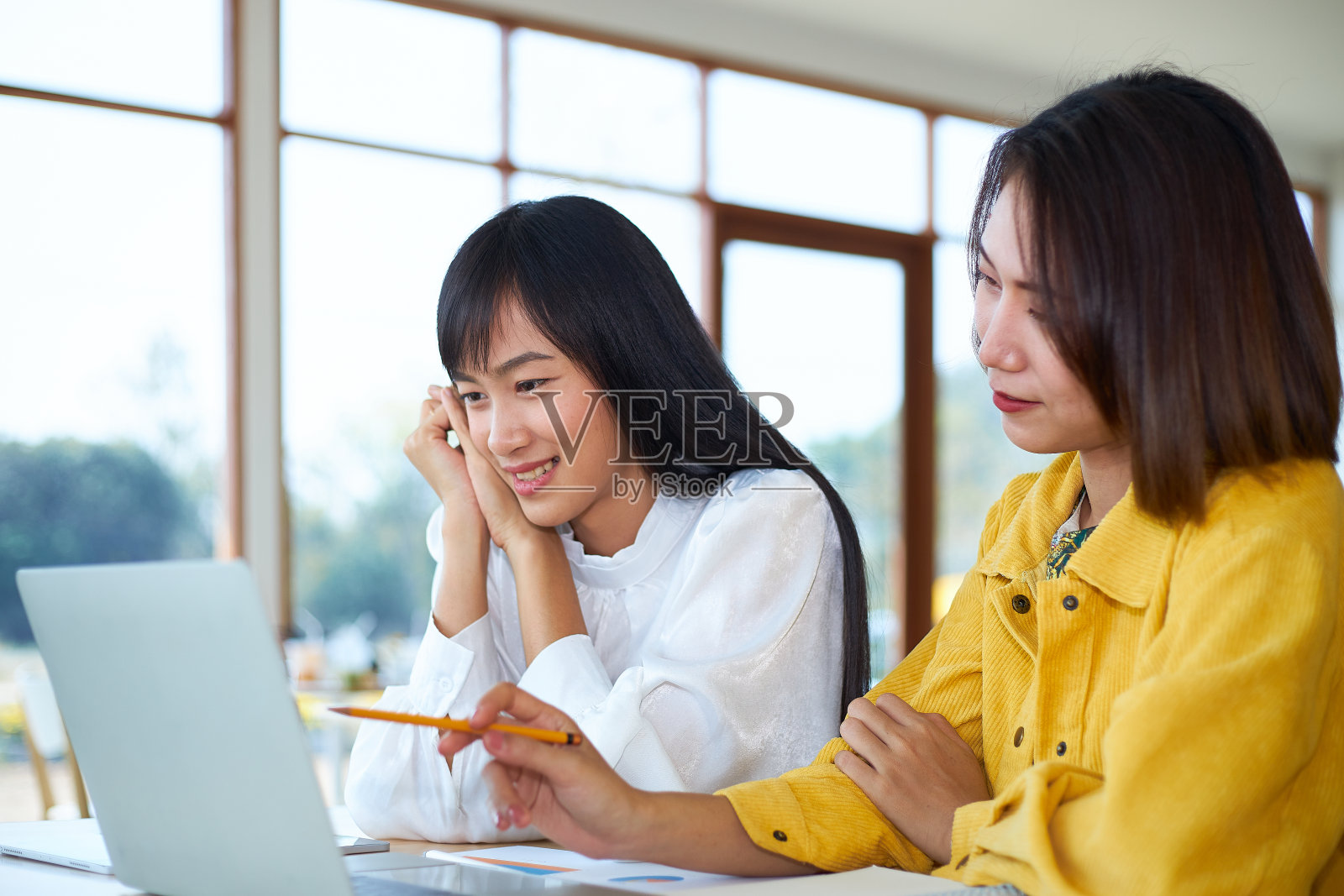 两个女人辅导或在咖啡店工作。照片摄影图片