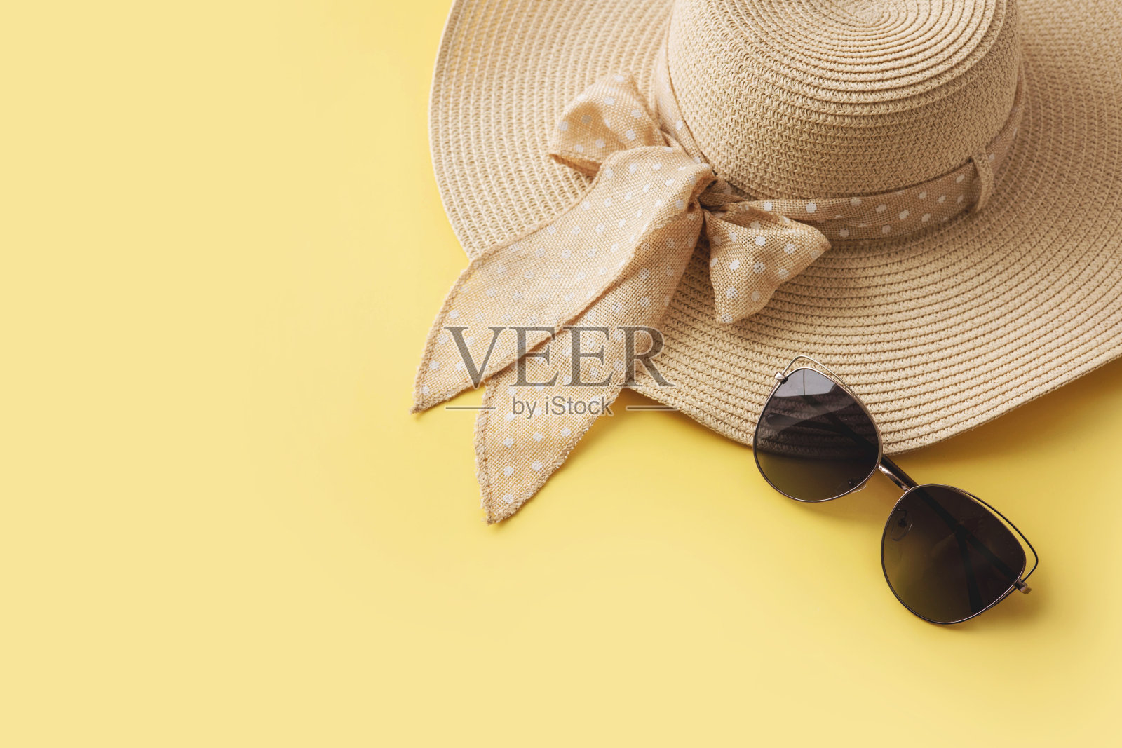 草帽和太阳镜在黄色的背景。暑假、假期、旅游概念。平铺，俯视图，拷贝空间。最小的风格照片摄影图片