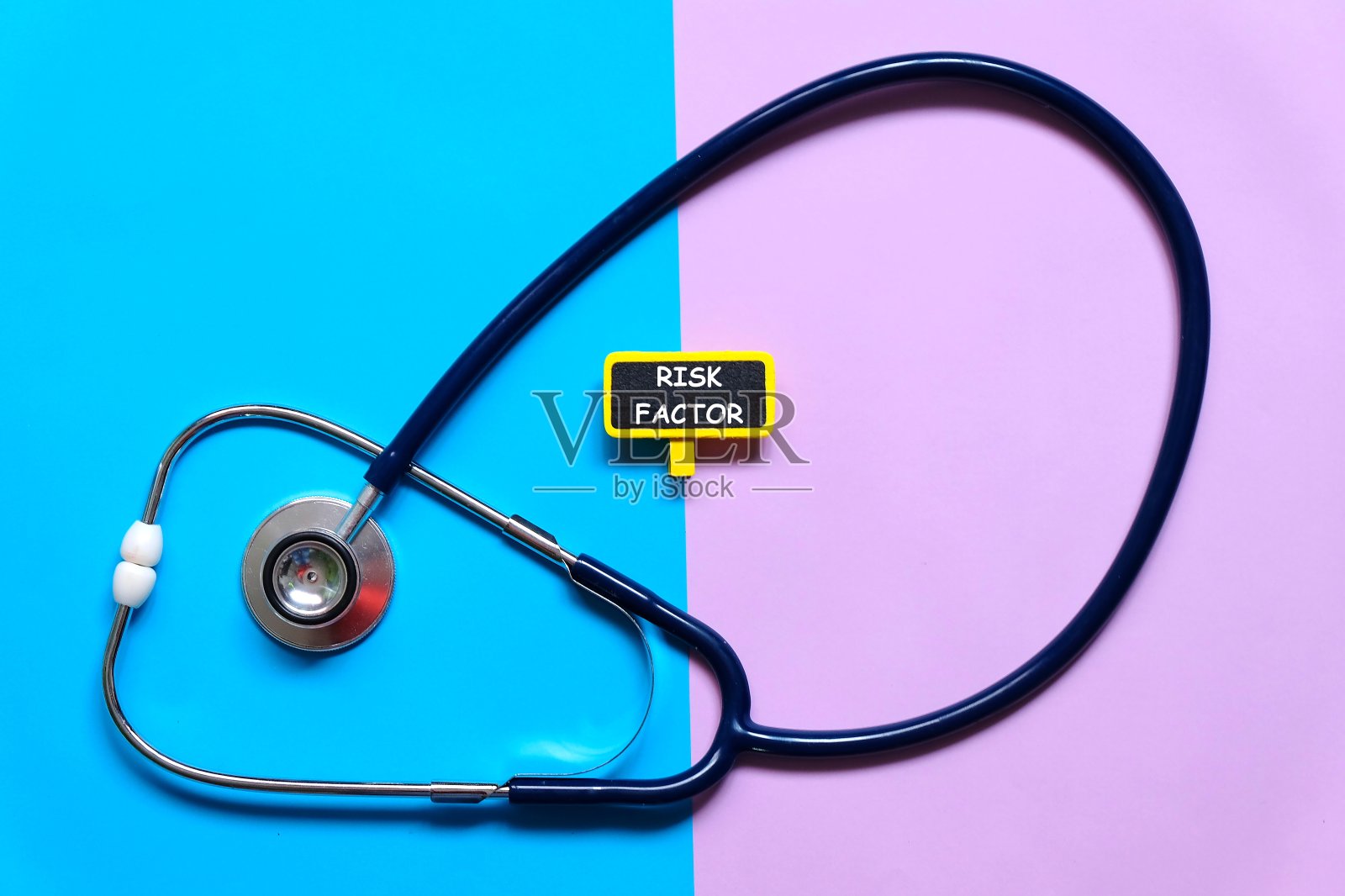 听诊器和黑板的选择性焦点，蓝色和紫色的背景上写有“危险因素”。两种色调的背景。医疗保健和医疗理念。照片摄影图片