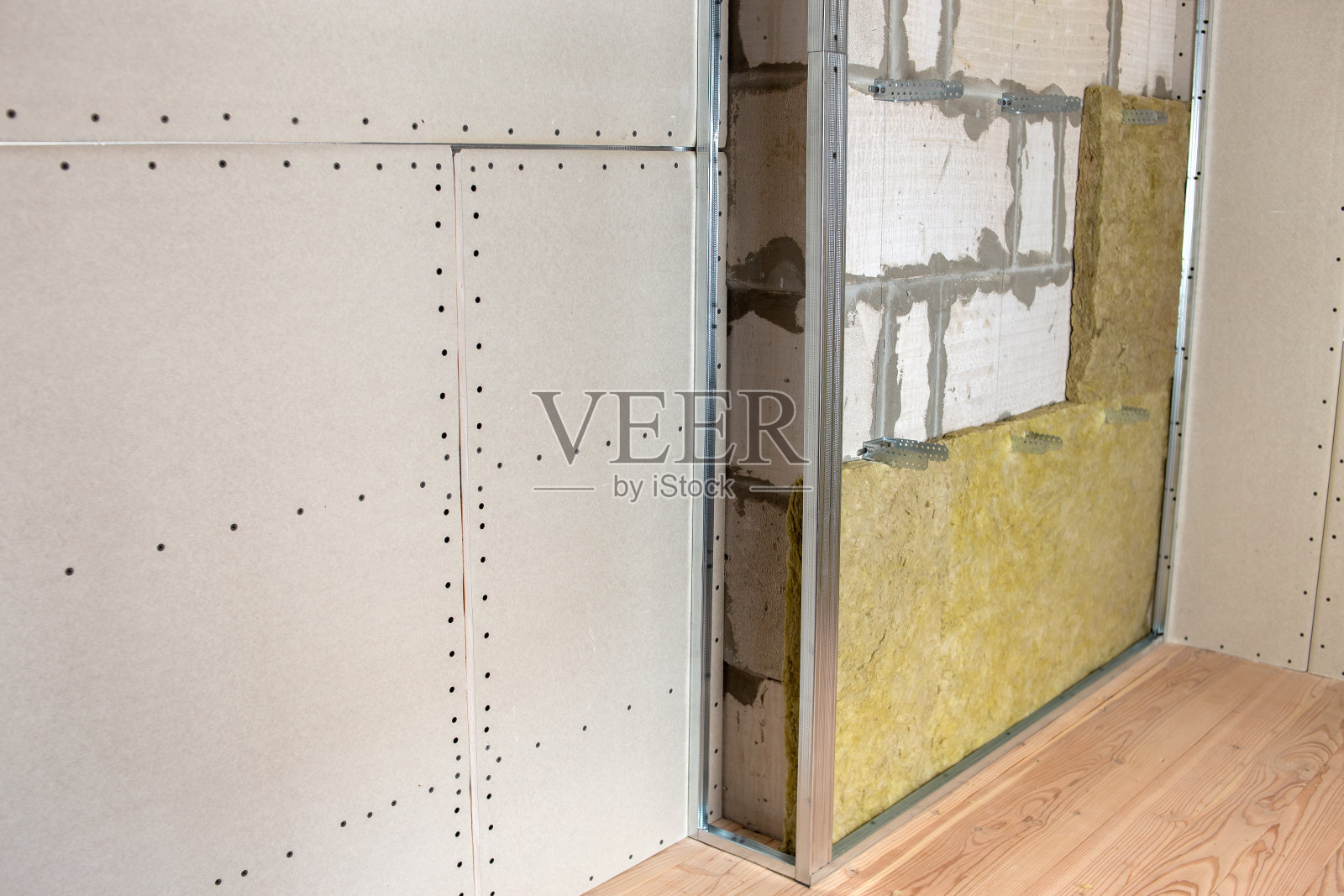 正在翻新的房间墙壁，采用矿物岩棉绝缘材料和为干墙板准备的金属框架。照片摄影图片