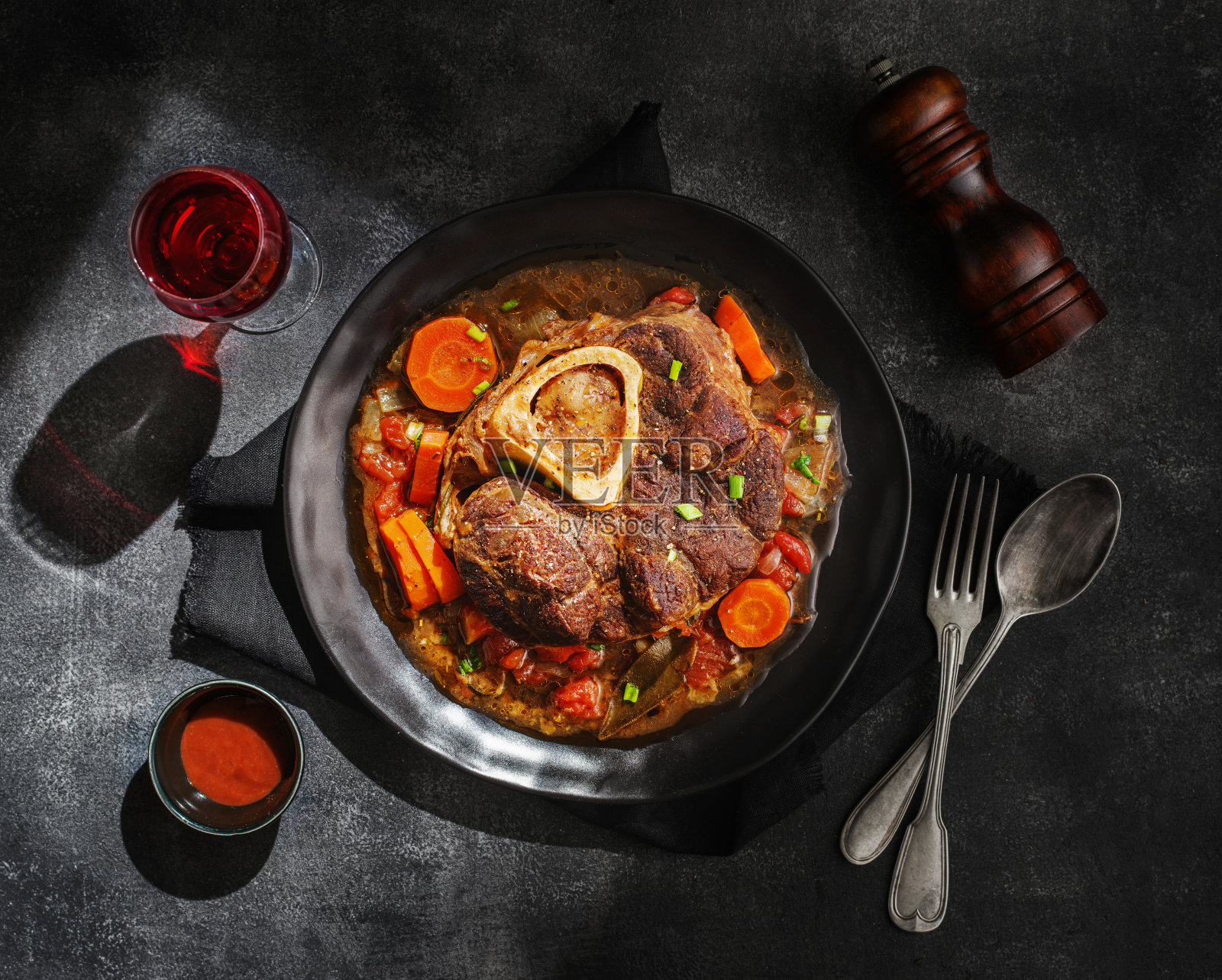 牛腿配骨髓片。意大利菜单:米兰炖牛肉配蔬菜酱。俯视图照片摄影图片