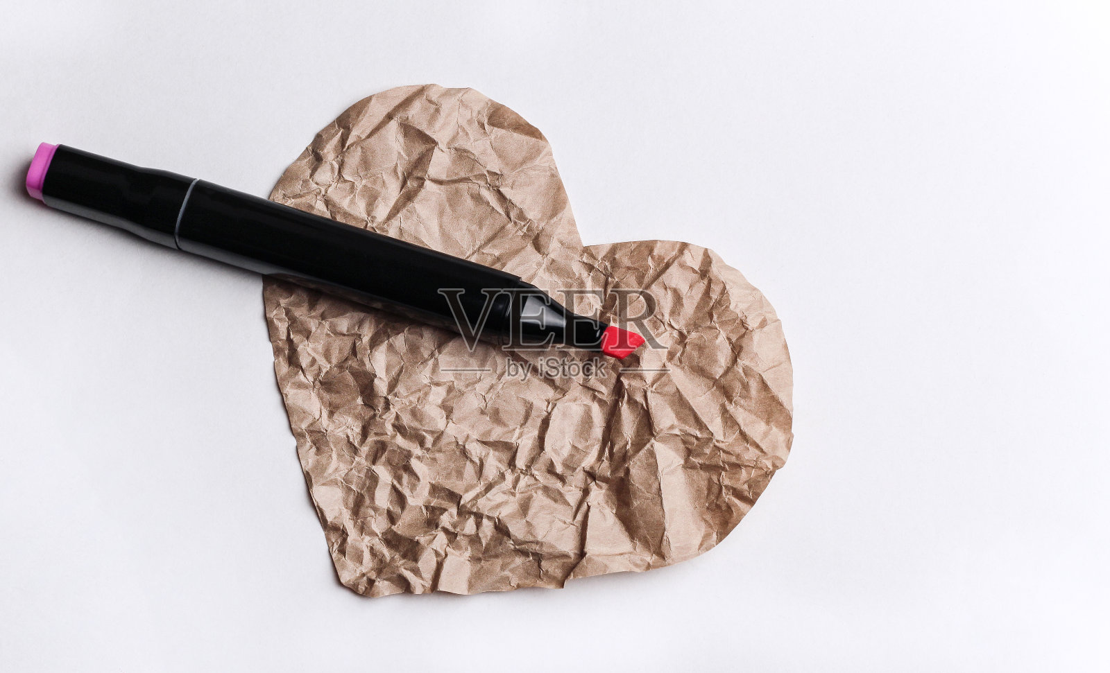 心形的纸与粉红色毡尖笔在白色的背景。照片摄影图片