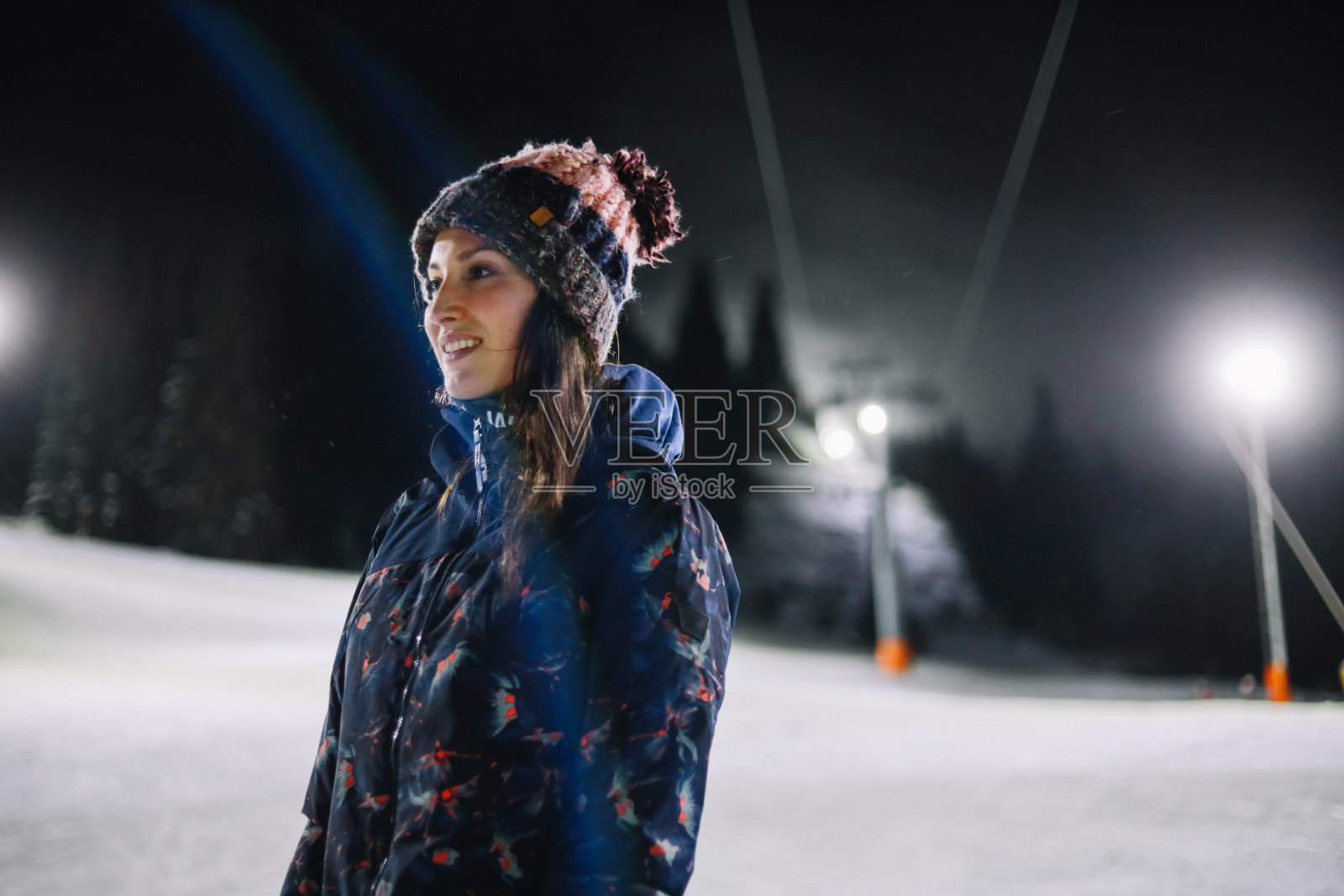 晚上在滑雪胜地徒步旅行的年轻女子照片摄影图片