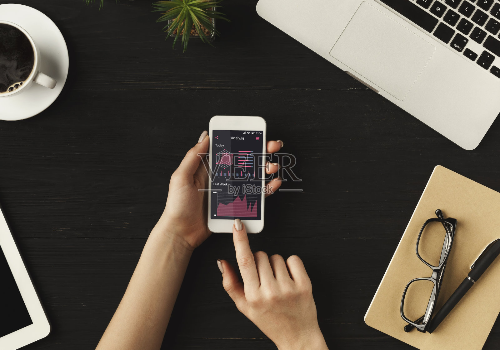 数据分析。一个面目全非的女商人在用屏幕上有图表的智能手机照片摄影图片