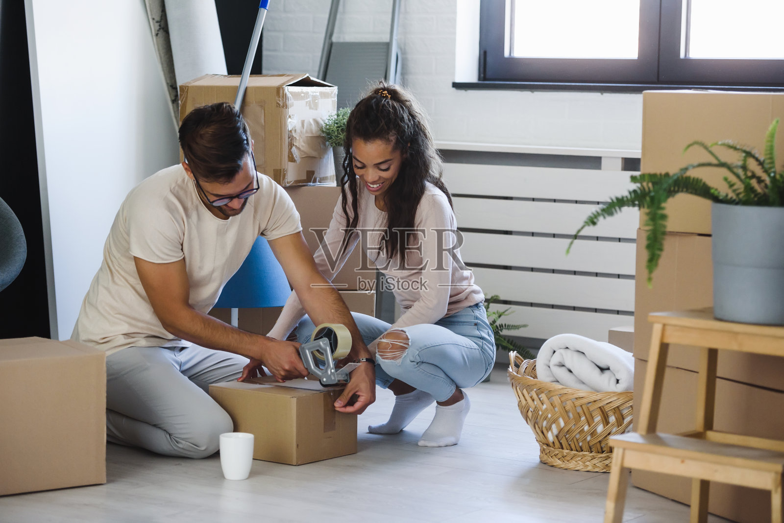 一对漂亮的夫妇刚搬进新公寓。在移动。搬迁的夫妇。照片摄影图片