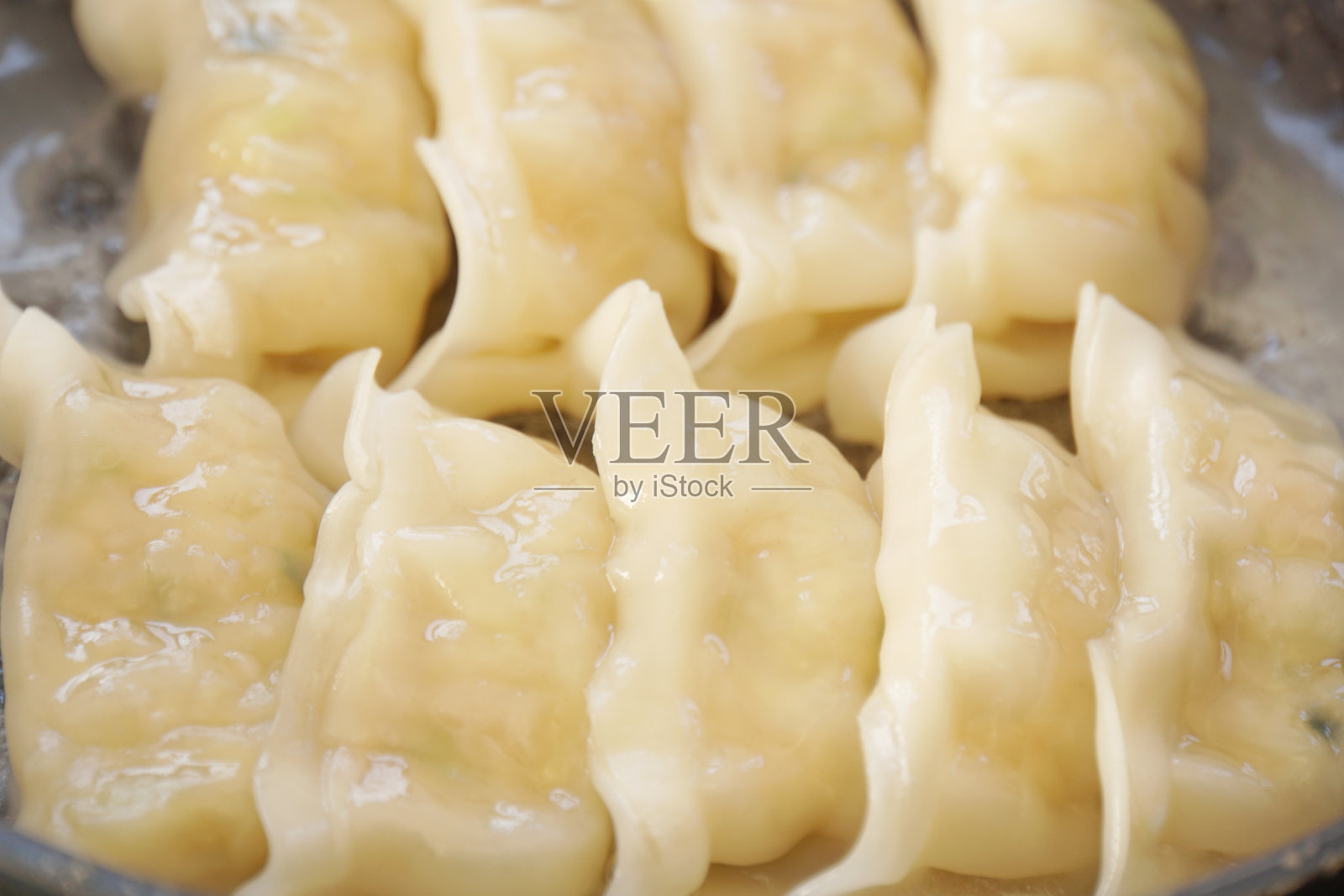 用煎锅煮饺子。照片摄影图片