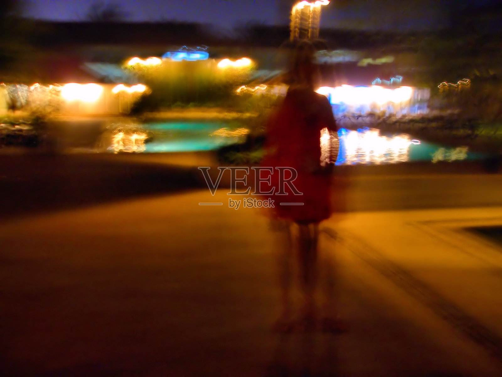 运动模糊的剪影孤独的女人走在夜晚的堤岸上的节日灯光照片摄影图片