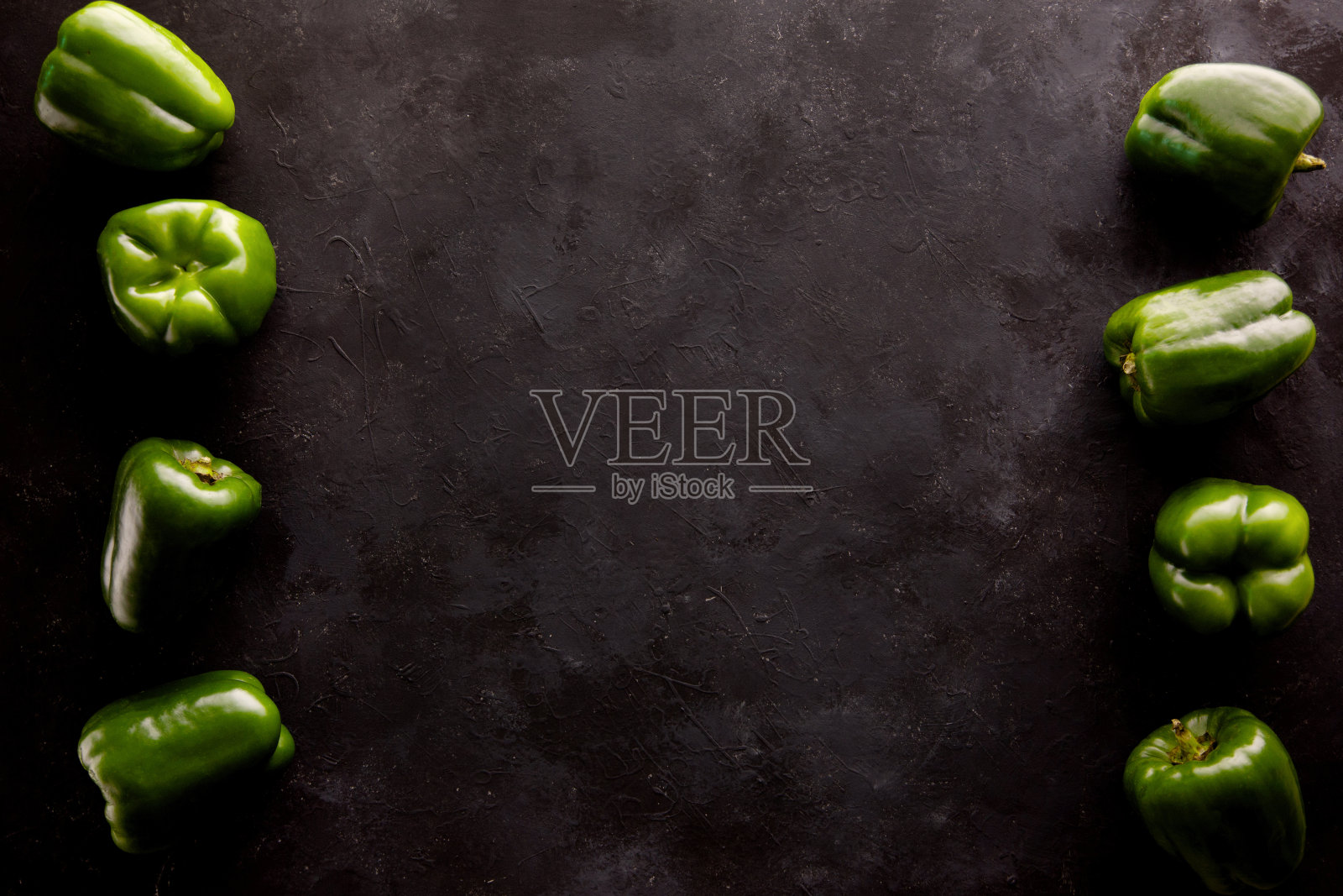 甜青椒背景与拷贝空间在深灰色和黑色的厨房桌子上。照片摄影图片