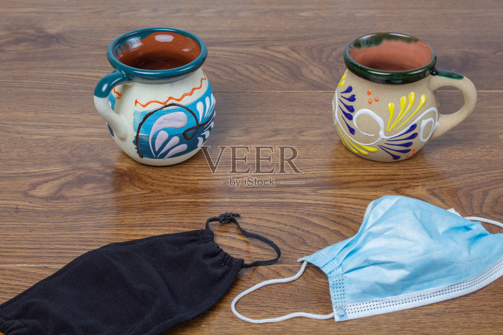 桌子上放着墨西哥咖啡杯，旁边是不同材质的口罩照片摄影图片